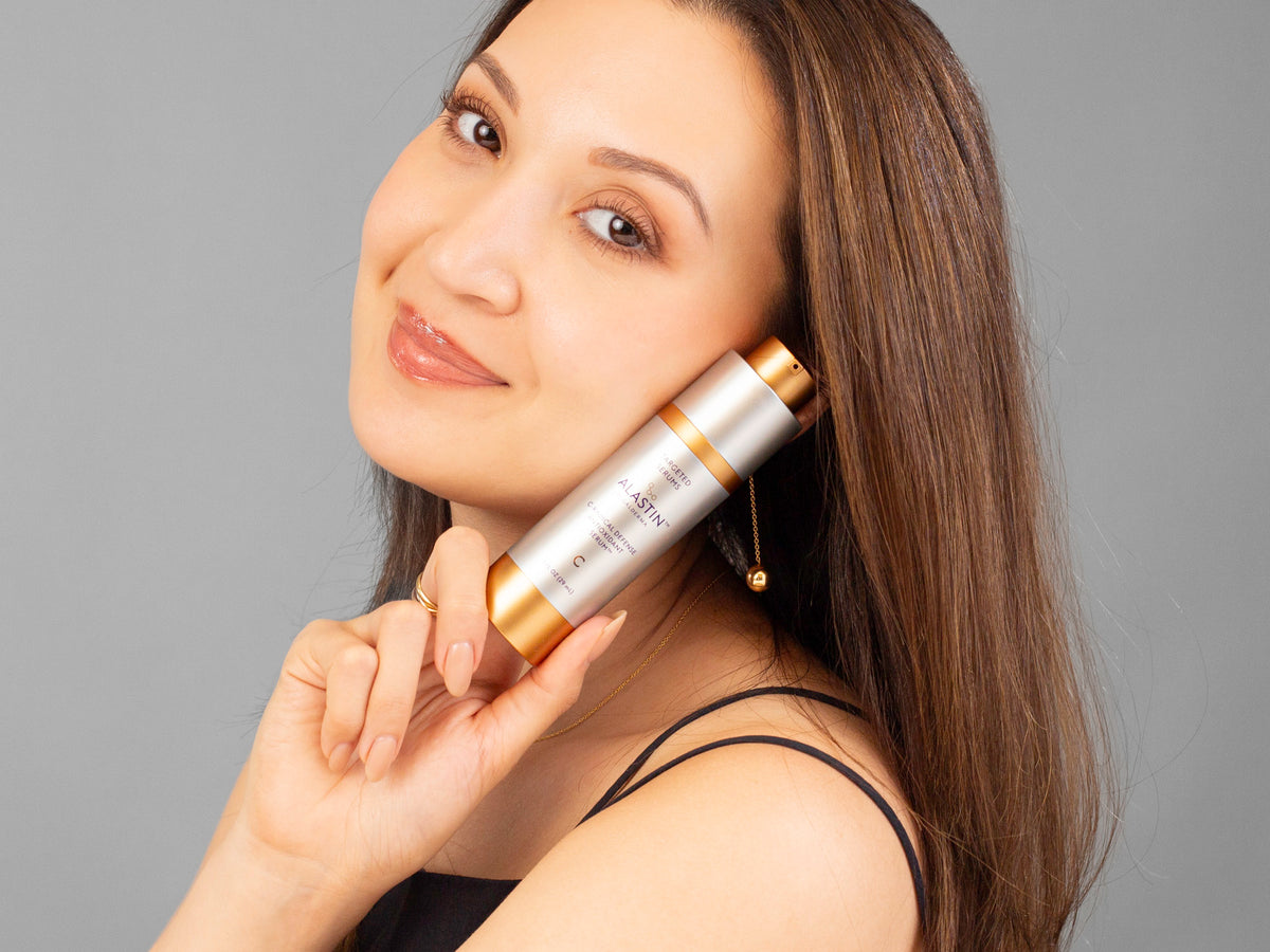 Laziza from LAZ Skincare holding a bottle of Alastin C-Radical Defense Antioxidant Serum up to her face