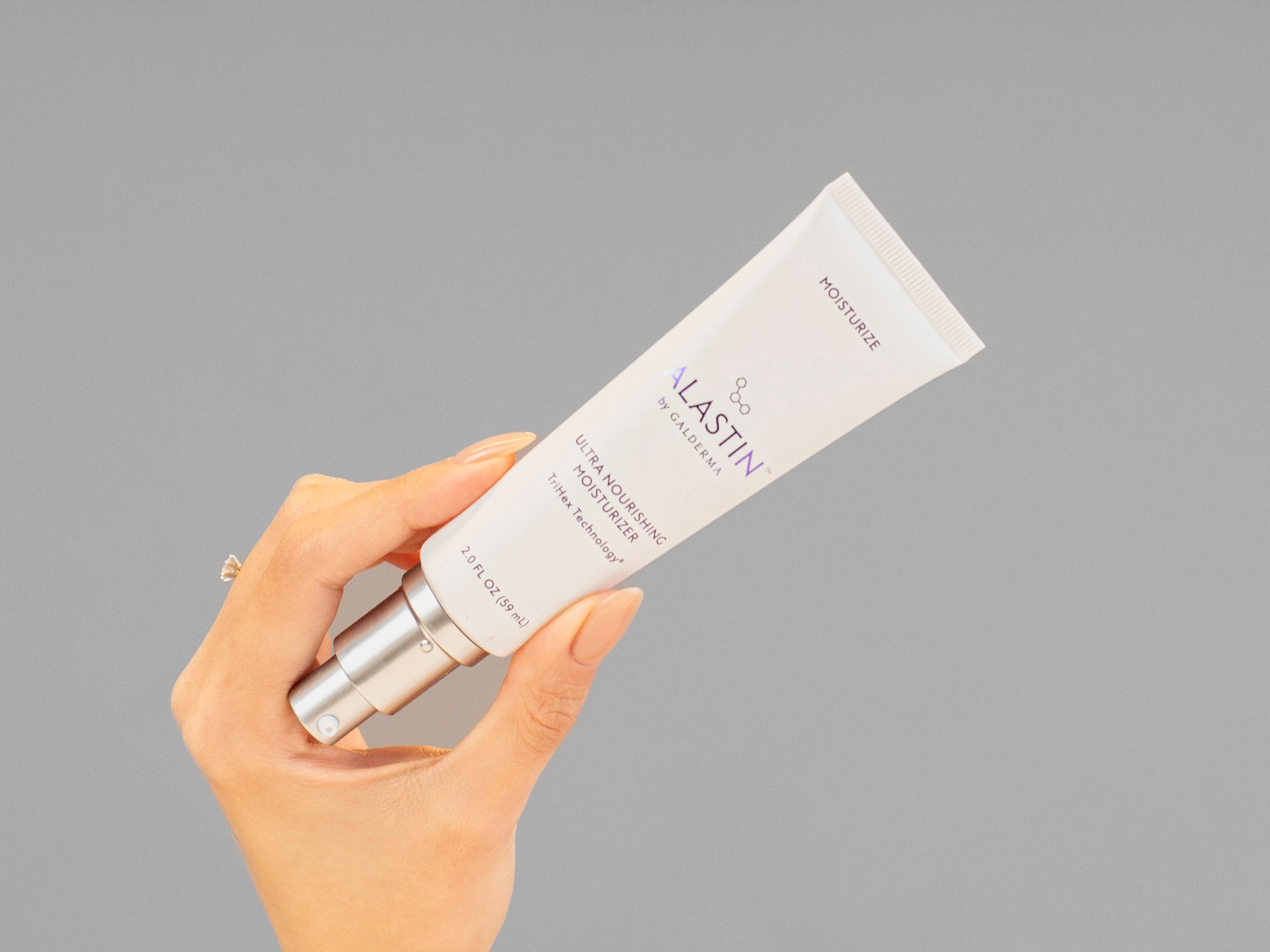 Closeup of Laziza from LAZ Skincare holding up a bottle of Alastin Ultra Nourishing Moisturizer