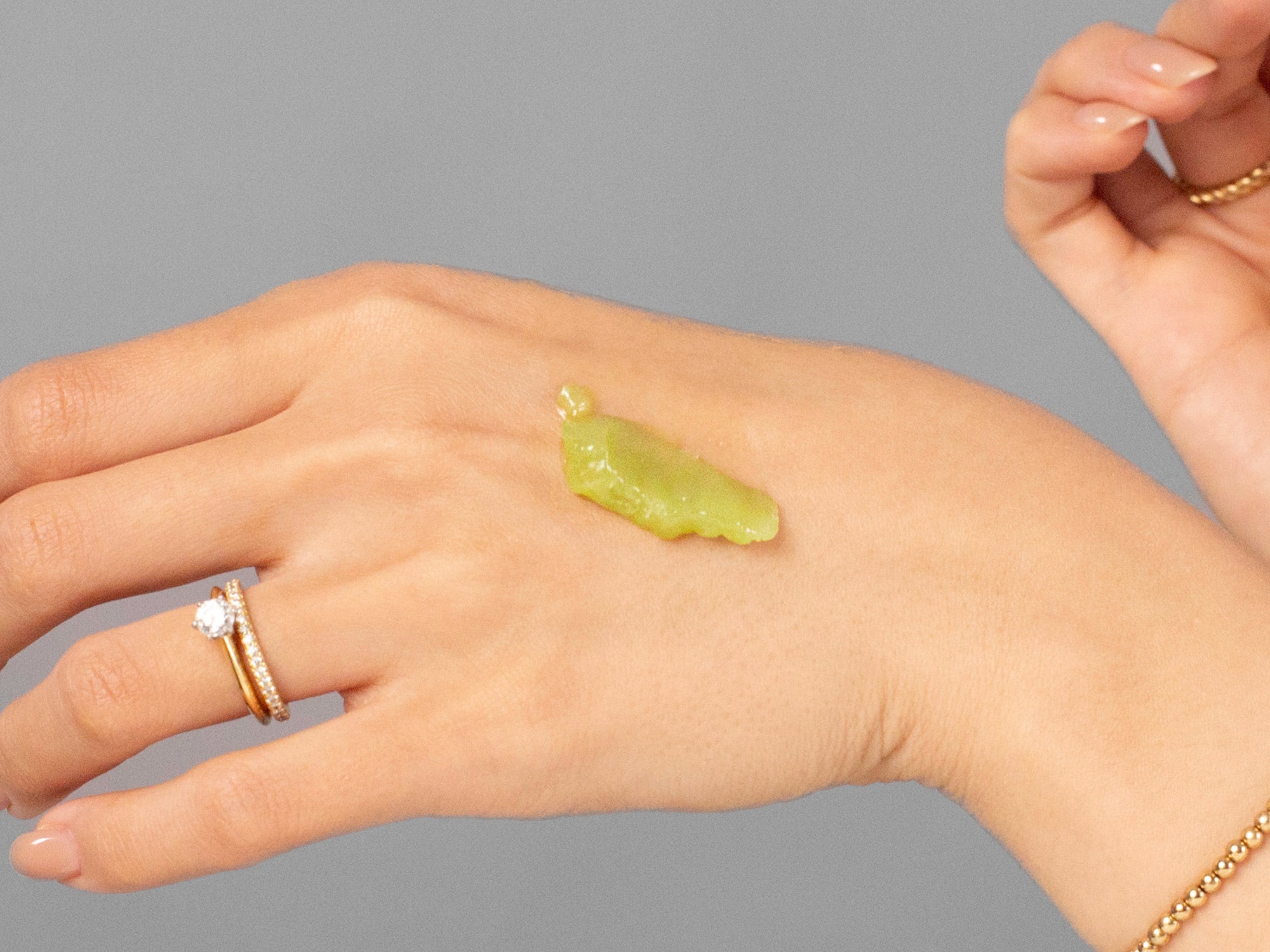 Closeup of Laziza from LAZ Skincare applying Anfisa AN-BALM to her hand