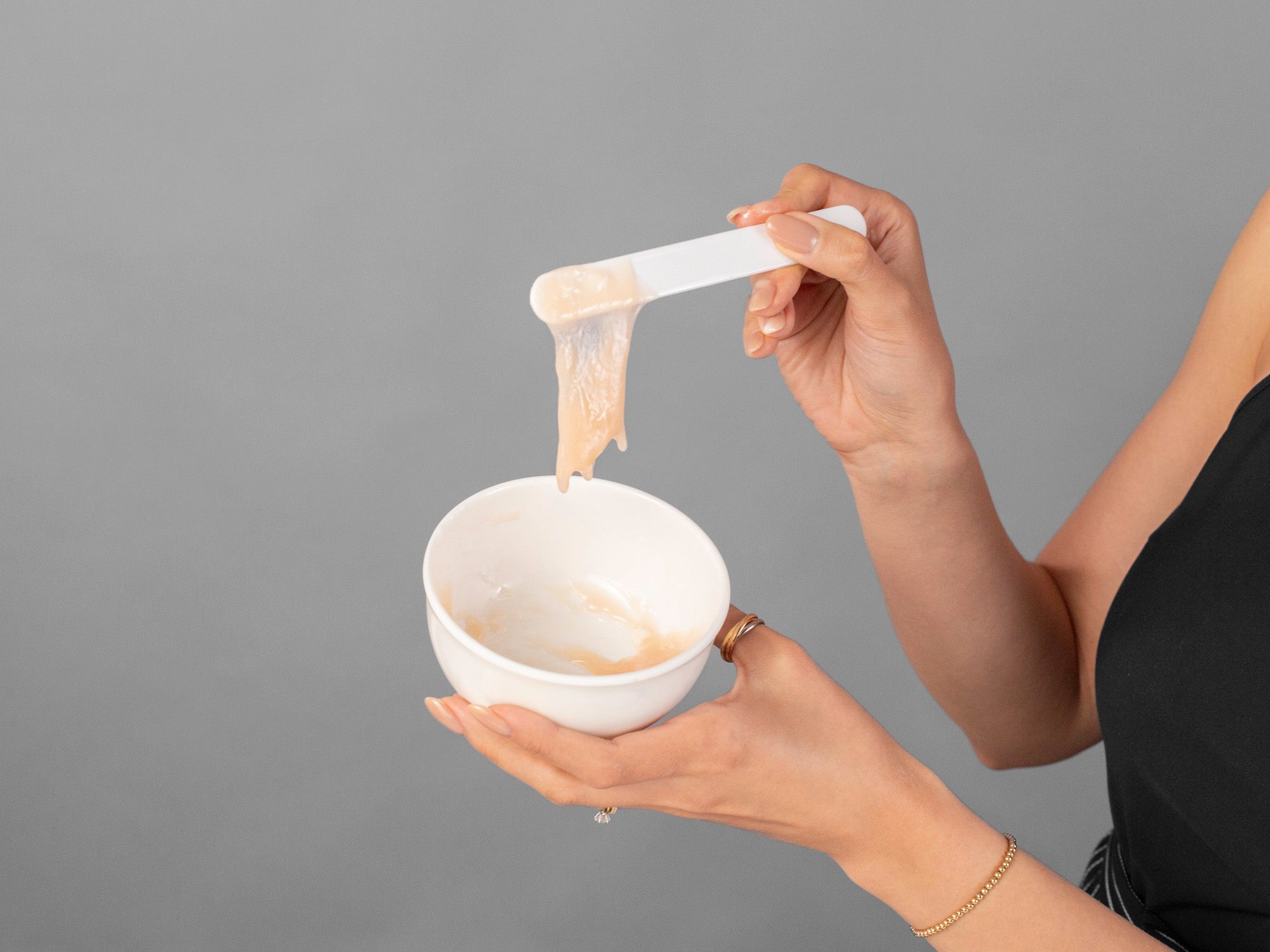 Closeup of Laziza from LAZ Skincare demonstrating how to mix CO2Lift Pro Carboxy Gel Mask with the included spatula