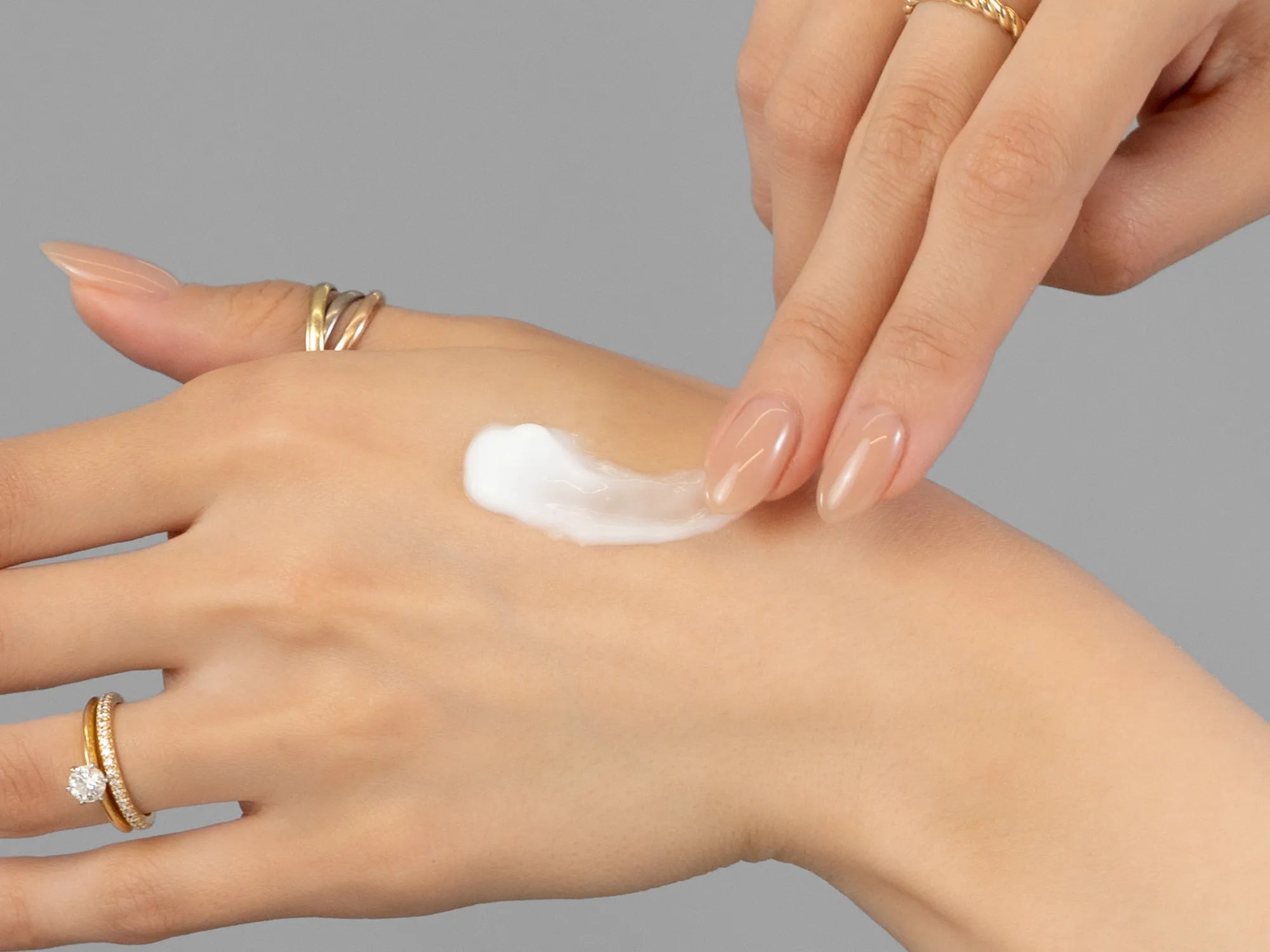 Laziza from LAZ Skincare demonstrating the texture and application of Environ Mela-Even Cream on her hand