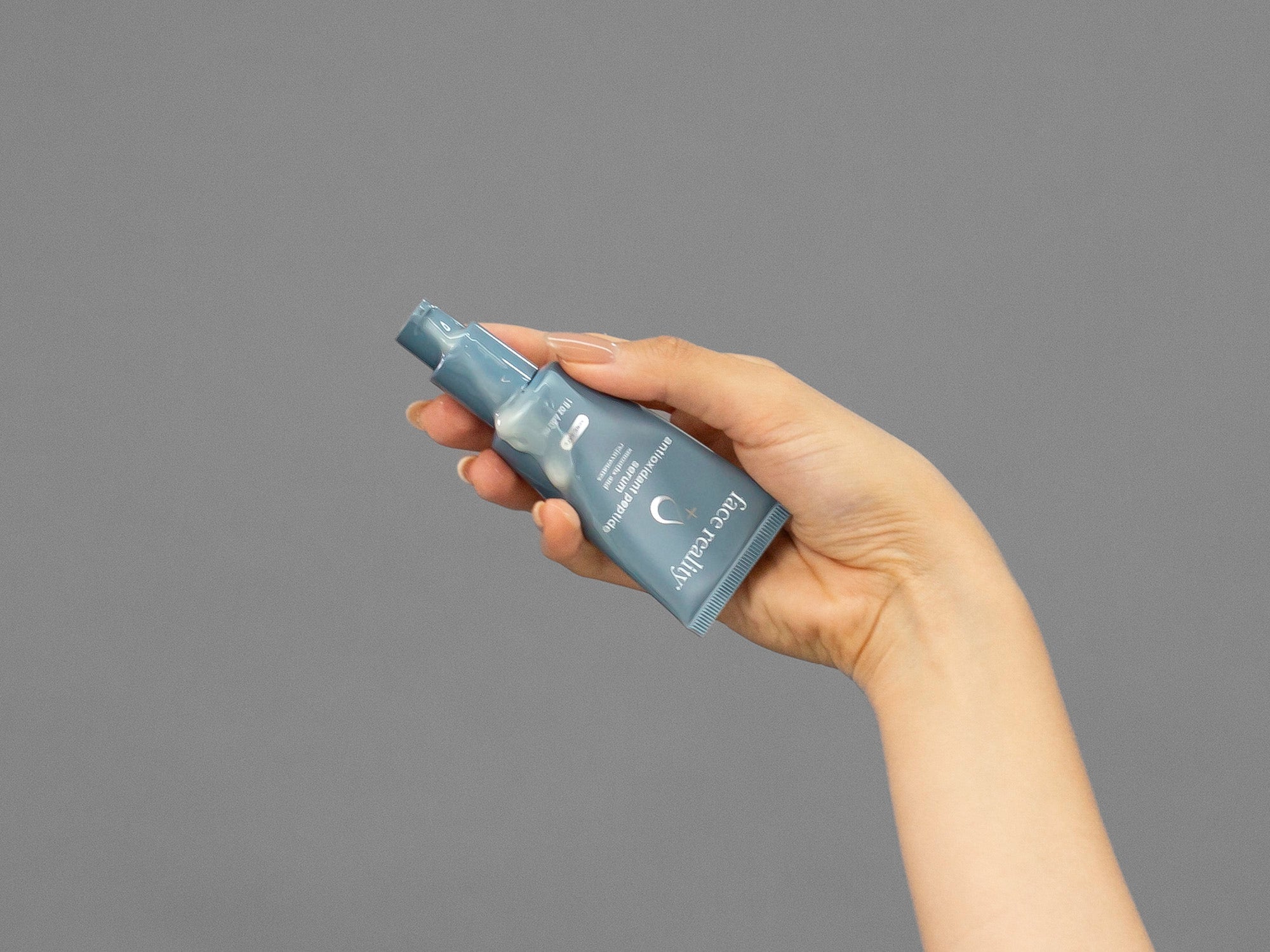 Closeup of Laziza from LAZ Skincare squeezing a tube of Face Reality Antioxidant Peptide Serum