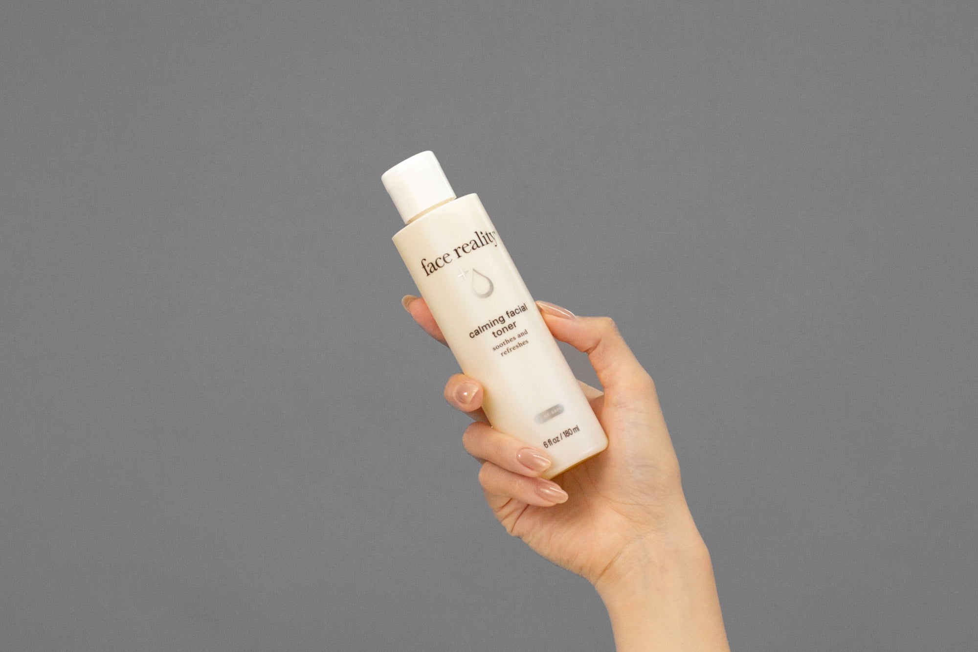 Closeup of Laziza from LAZ Skincare holding up a bottle of Face Reality Calming Facial Toner
