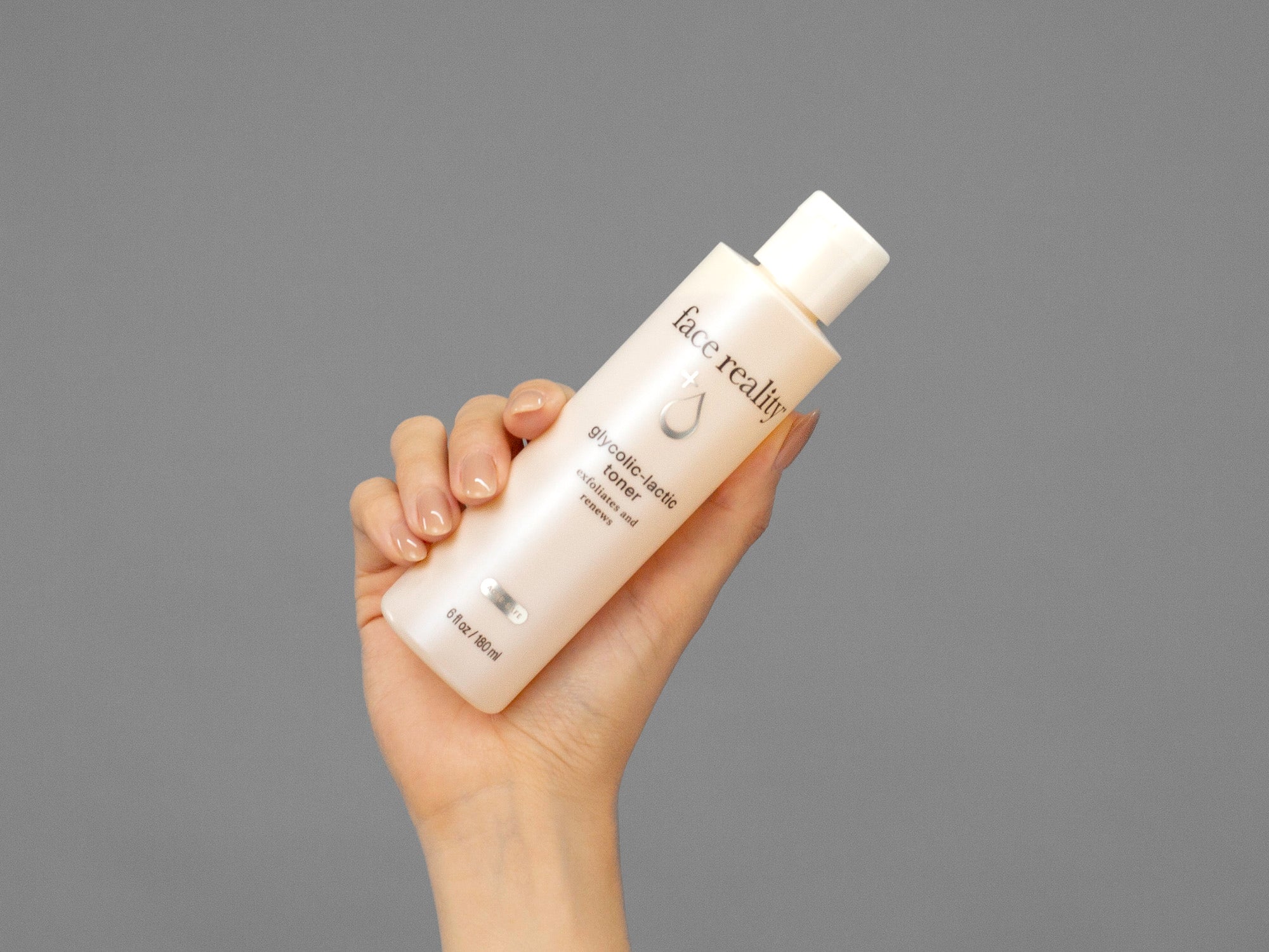 Closeup of Laziza from LAZ Skincare holding up a bottle of Face Reality Glycolic-Lactic Toner