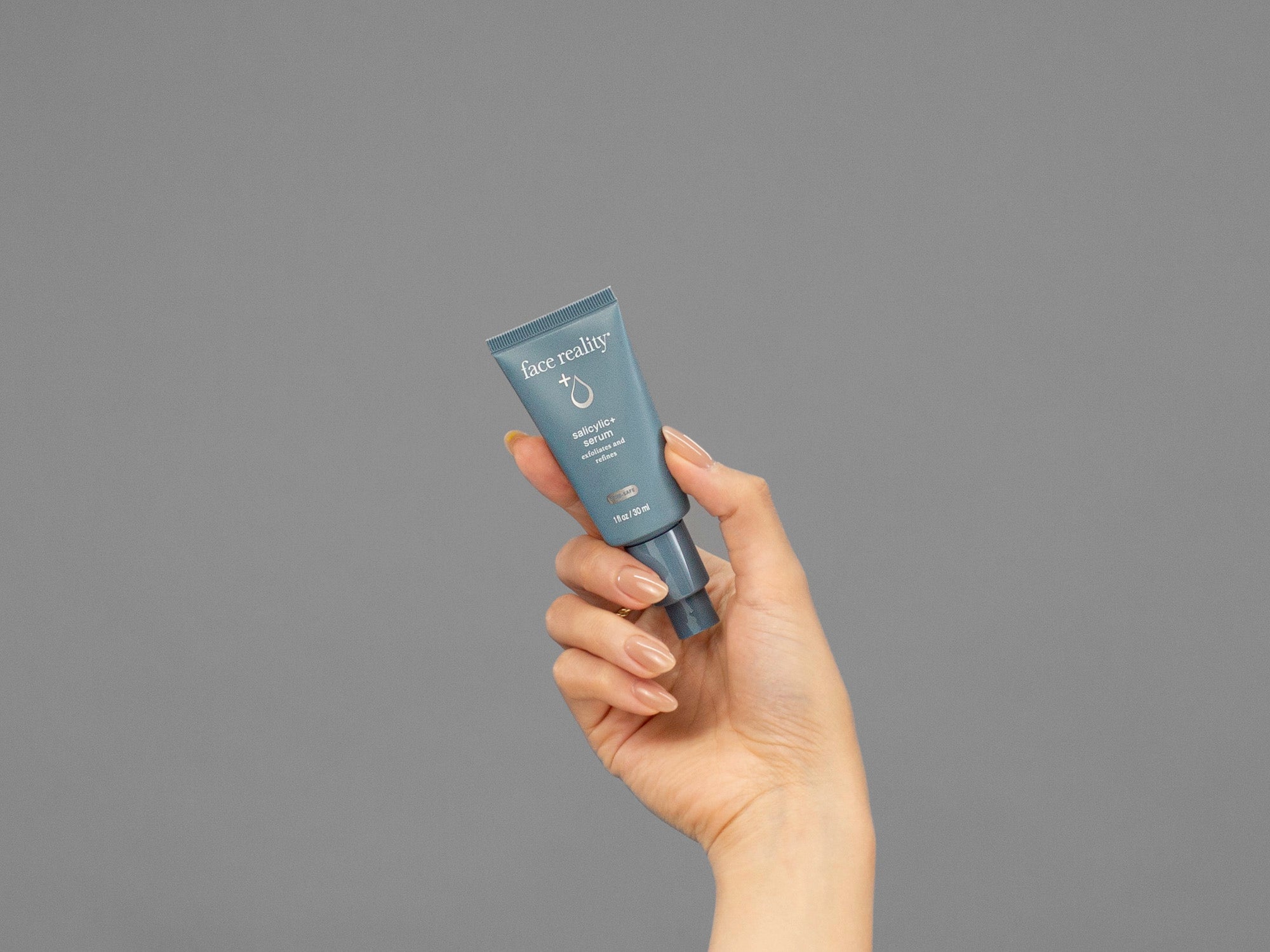 Closeup of Laziza from LAZ Skincare holding up a bottle of Face Reality Salicylic+ Serum