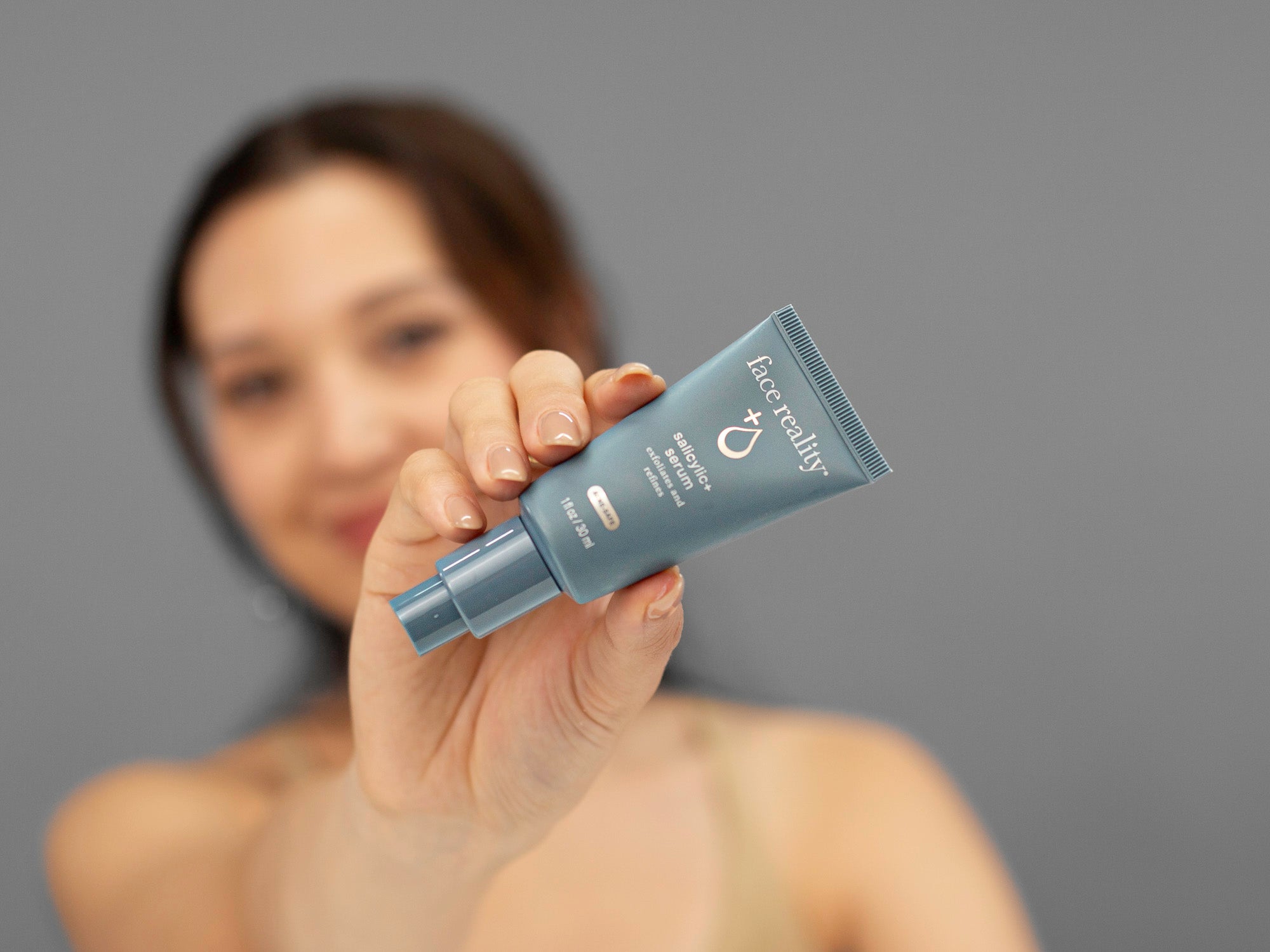 Laziza from LAZ Skincare demonstrating the texture and application of Face Reality Salicylic+ Serum on her hand