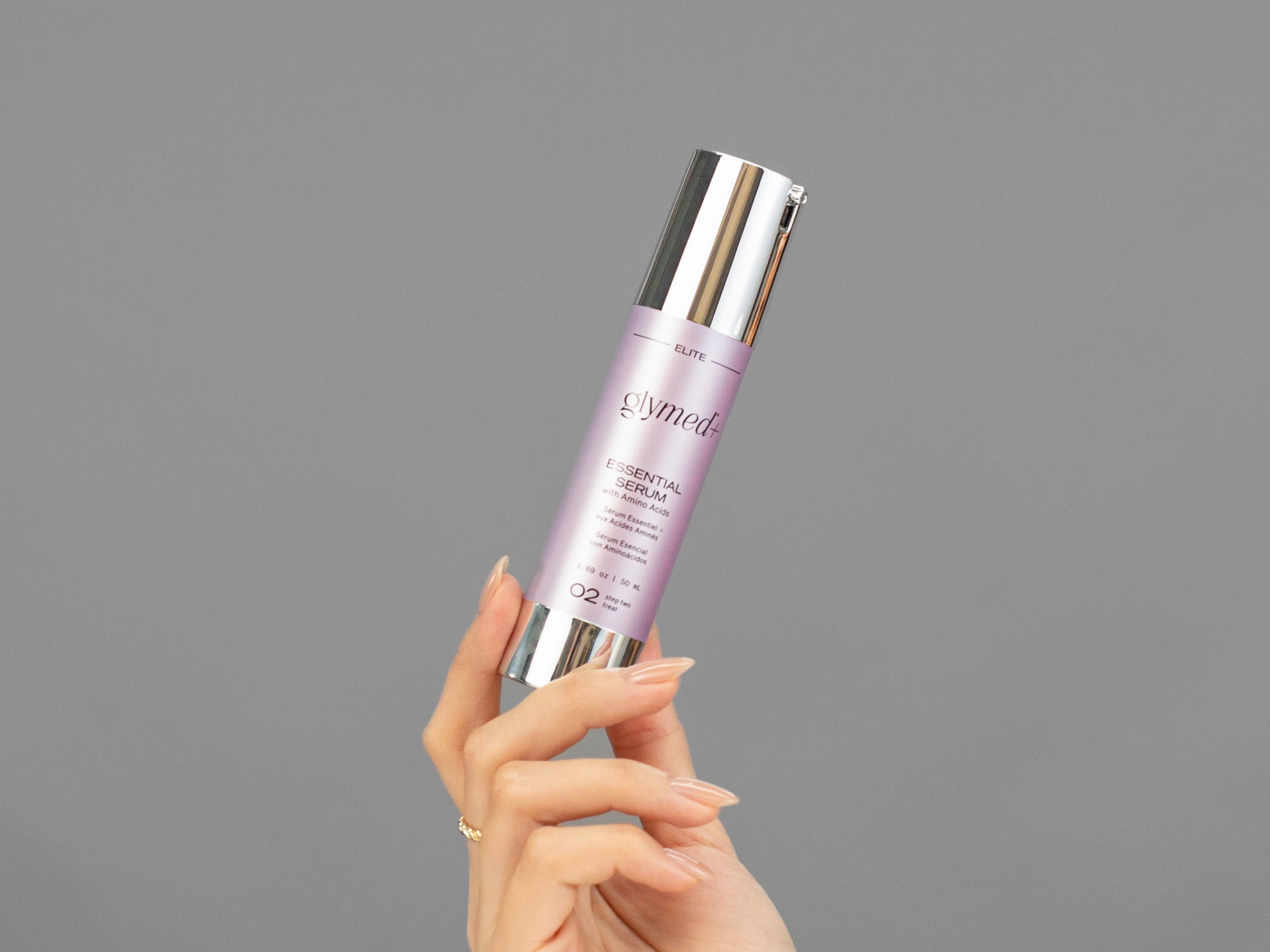 Closeup of Laziza from LAZ Skincare holding up a bottle of GlyMed Essential Serum