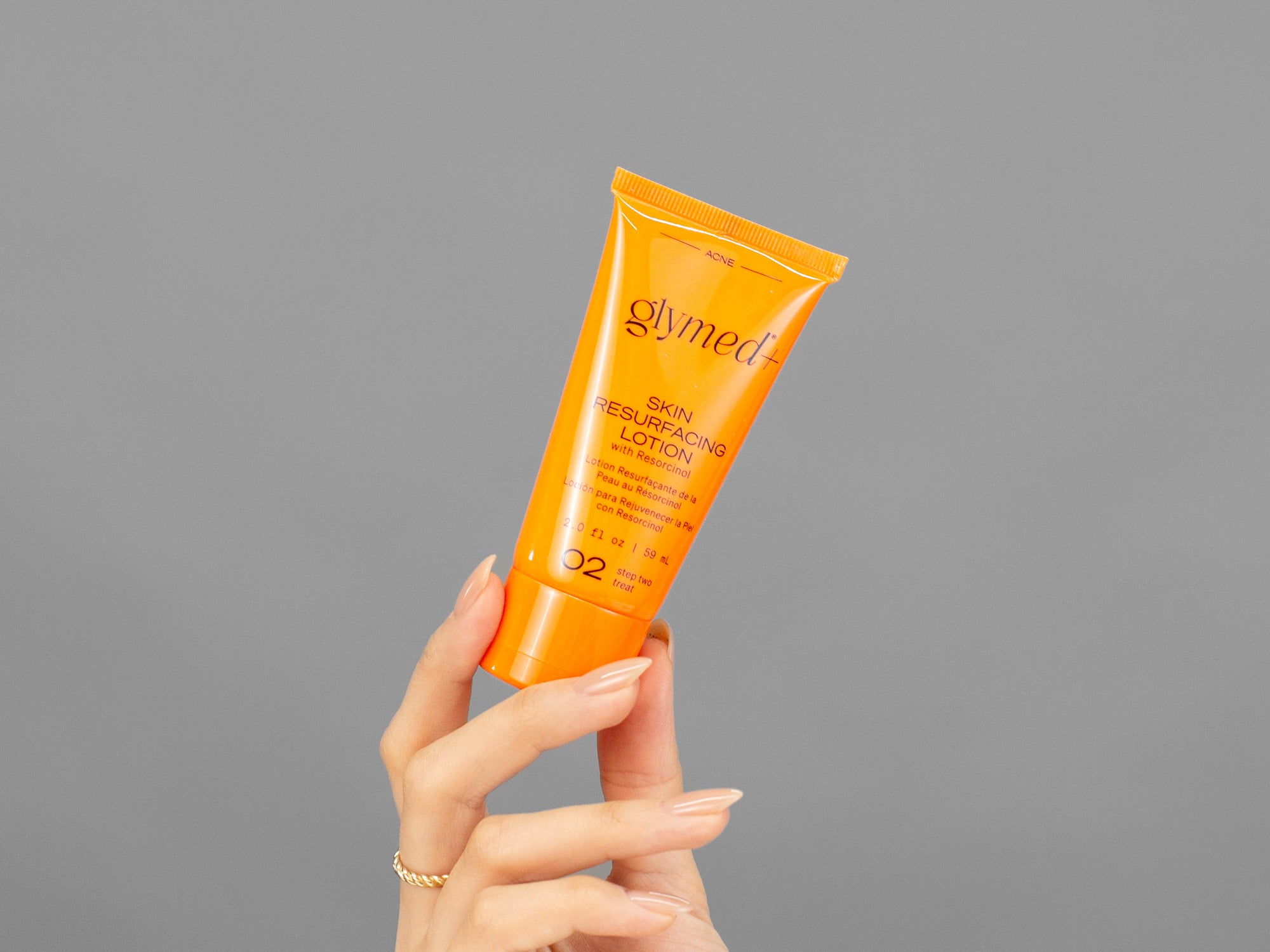Closeup of Laziza from LAZ Skincare holding up a bottle of GlyMed Skin Resurfacing Lotion