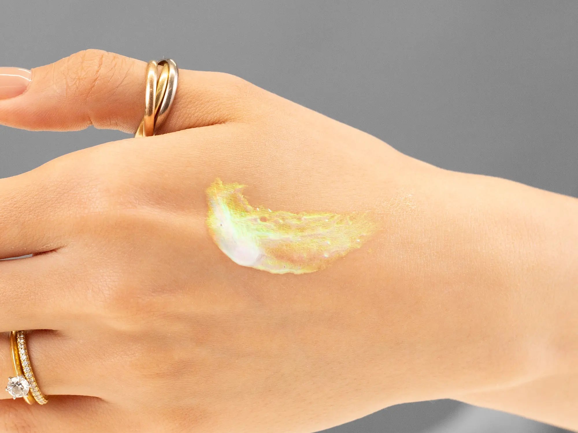 Laziza from LAZ Skincare demonstrating the texture and application of Hale & Hush Brilliant Eye & Lip Serum on her hand