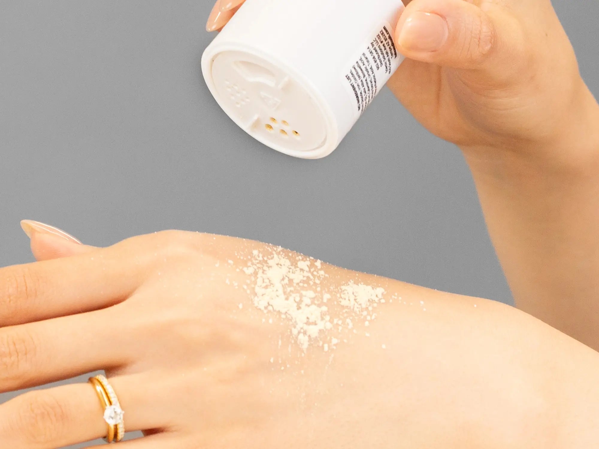 Laziza from LAZ Skincare demonstrating the texture and application of Hale & Hush Relief Bio-Powder on her hand