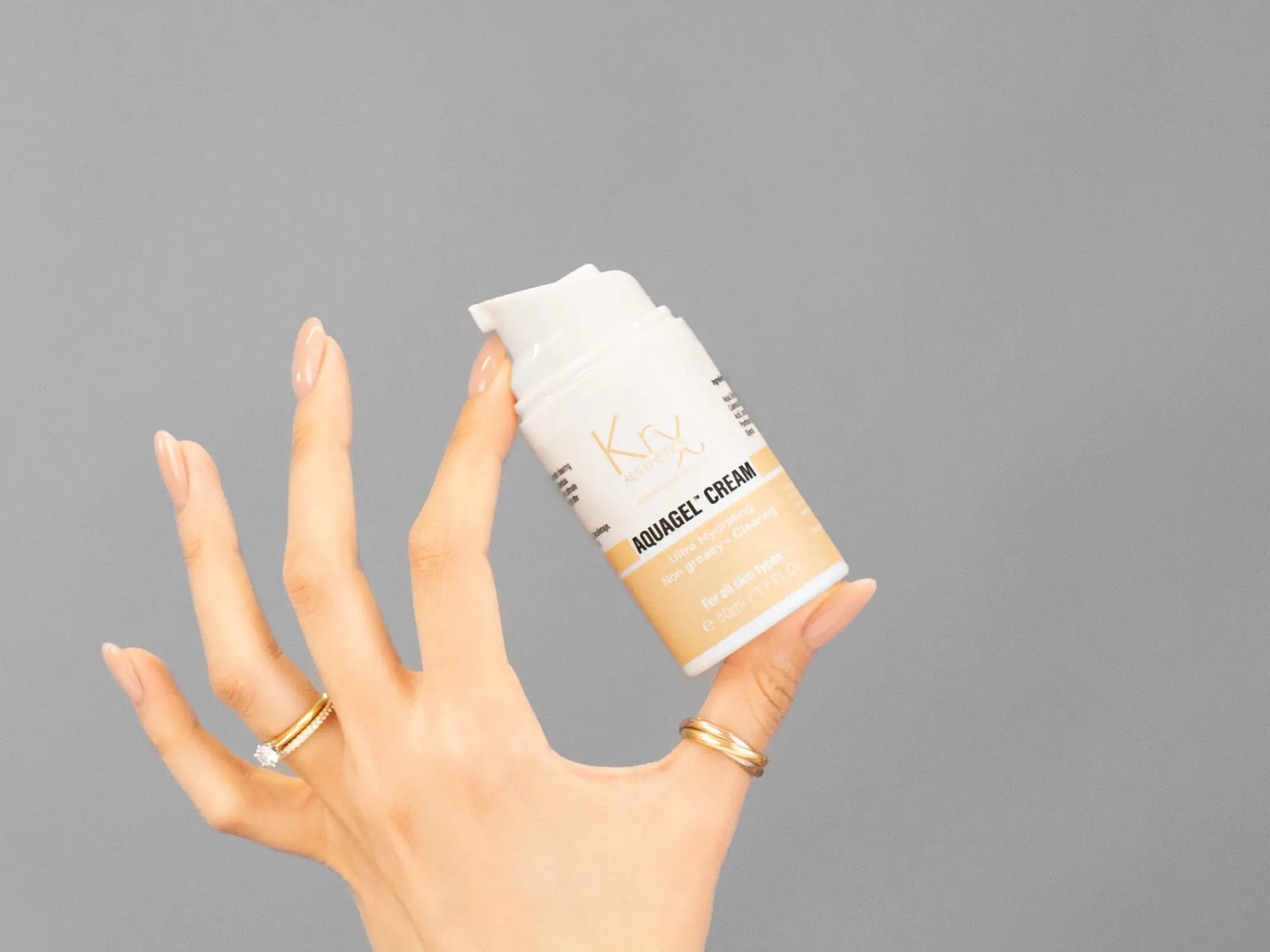 Closeup of Laziza from LAZ Skincare holding up a bottle of KrX Aesthetics AquaGel Cream