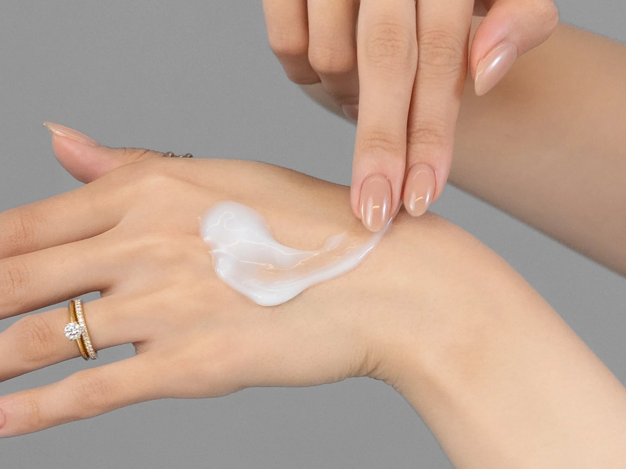 Laziza from LAZ Skincare demonstrating the texture and application of KrX Aesthetics AquaGel Cream on her hand