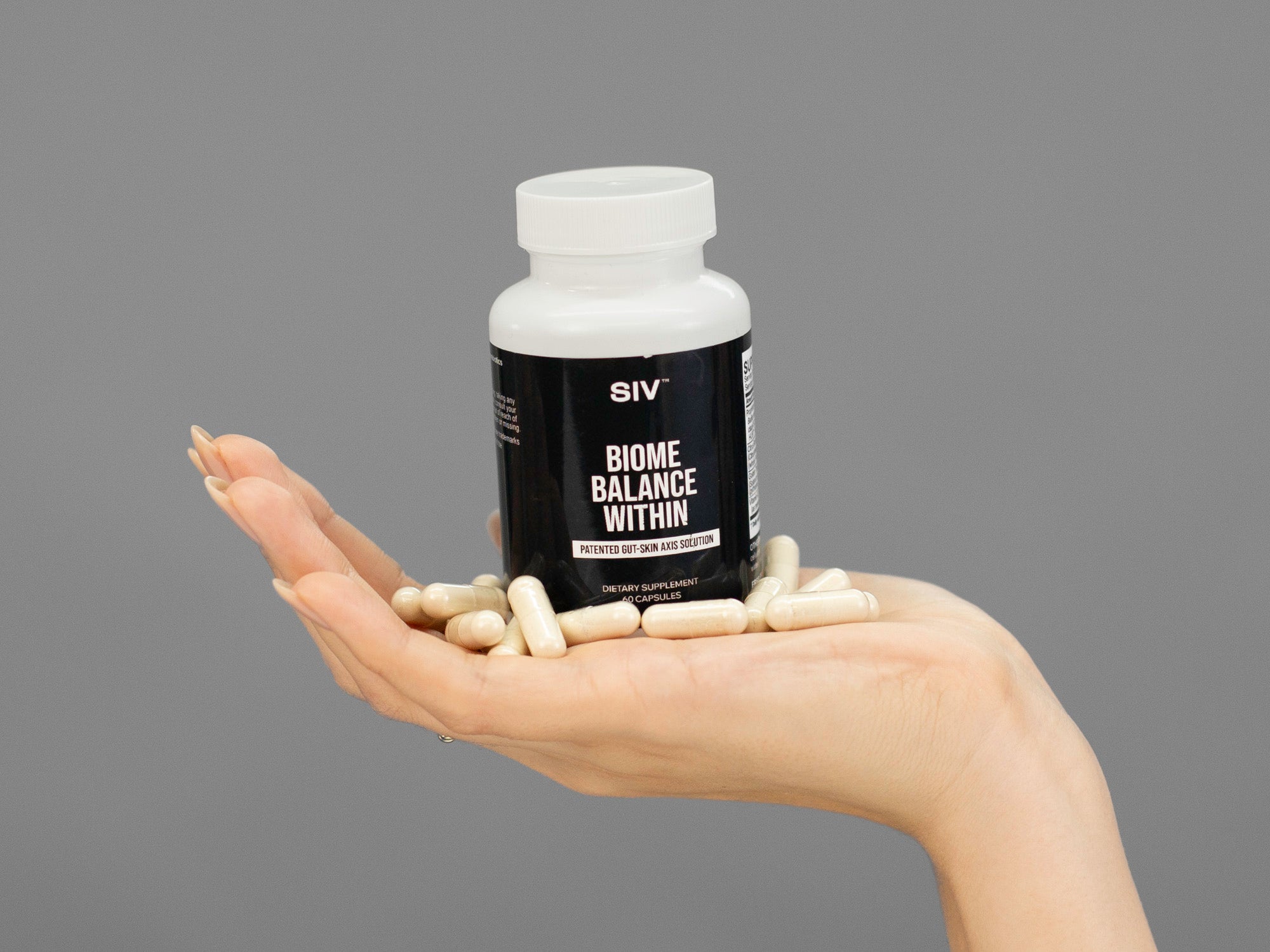 Closeup of Laziza from LAZ Skincare holding a bottle of SIV Biome Balance Within supplements