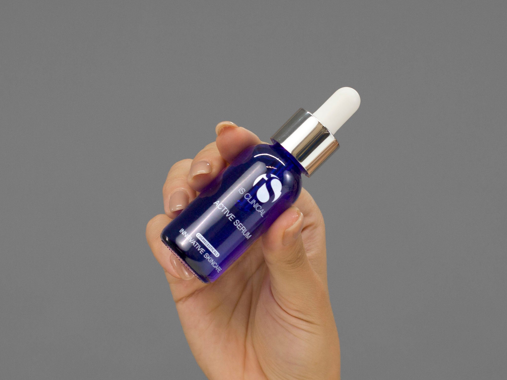 Closeup of Laziza from LAZ Skincare holding up a bottle of iS Clinical Active Serum