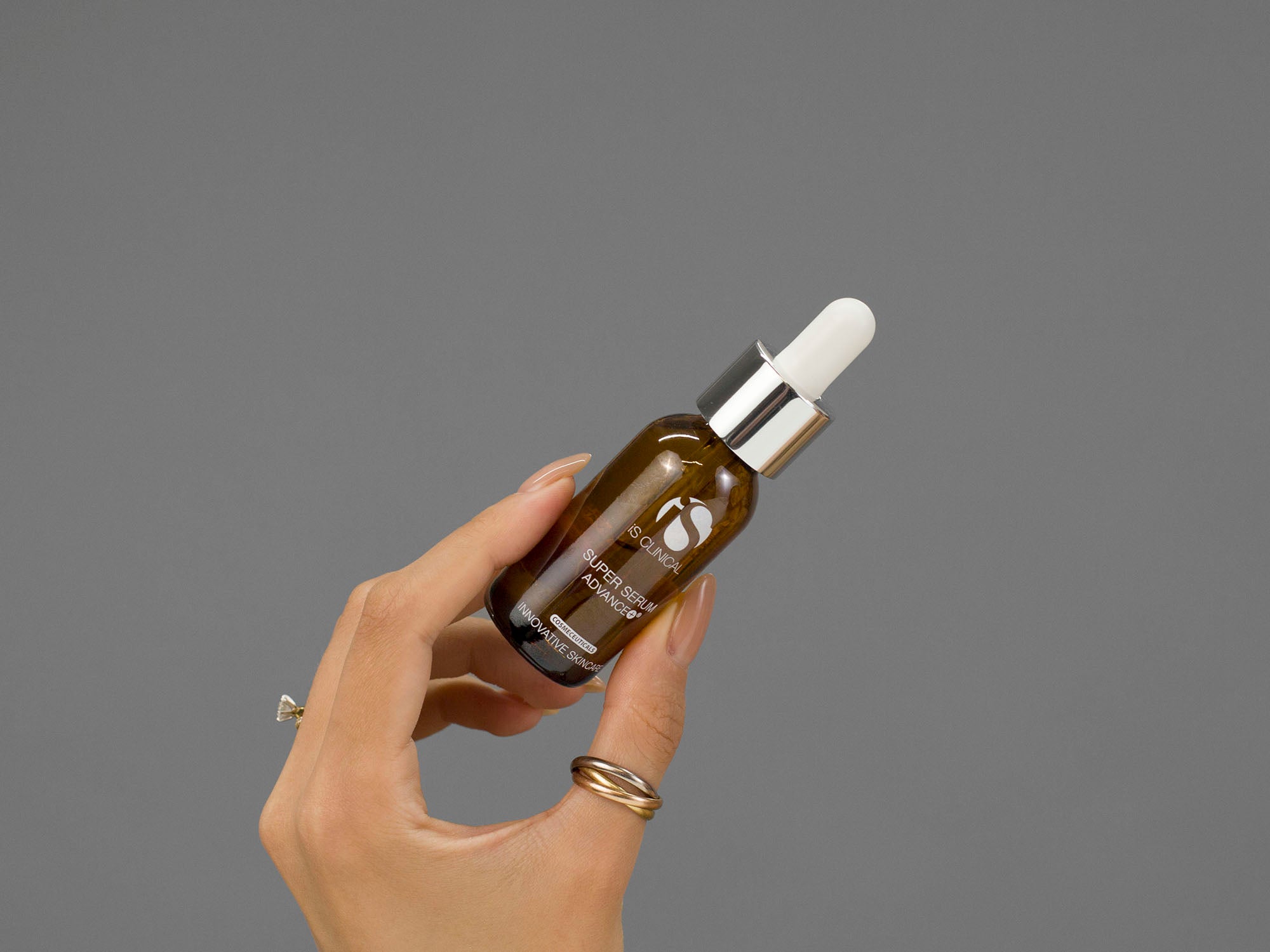 Closeup of Laziza from LAZ Skincare holding a bottle of iS Clinical Super Serum Advance in her hand