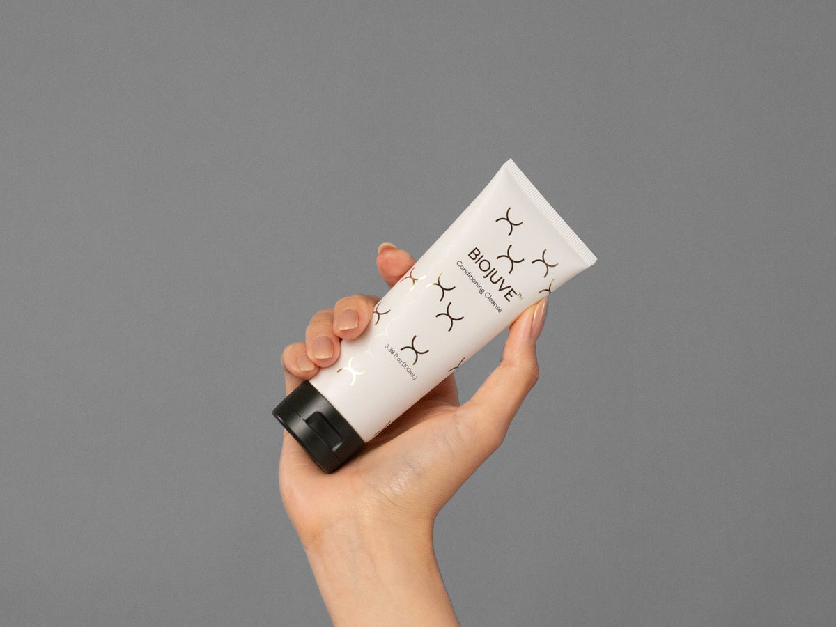 Closeup of Laziza from LAZ Skincare holding up a bottle of Biojuve Conditioning Cleanse