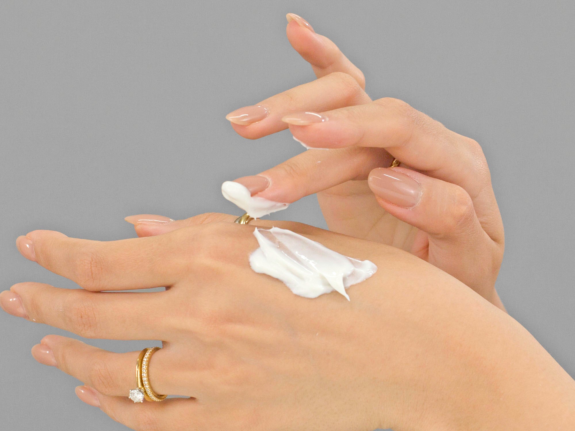 Closeup of Laziza from LAZ Skincare applying Calecim Multi-Action Cream to her hand