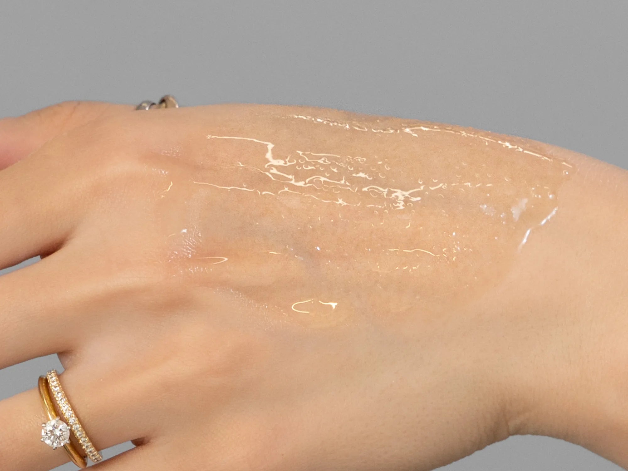 Laziza from LAZ Skincare demonstrating the texture and application of Environ Body Oil on her hand