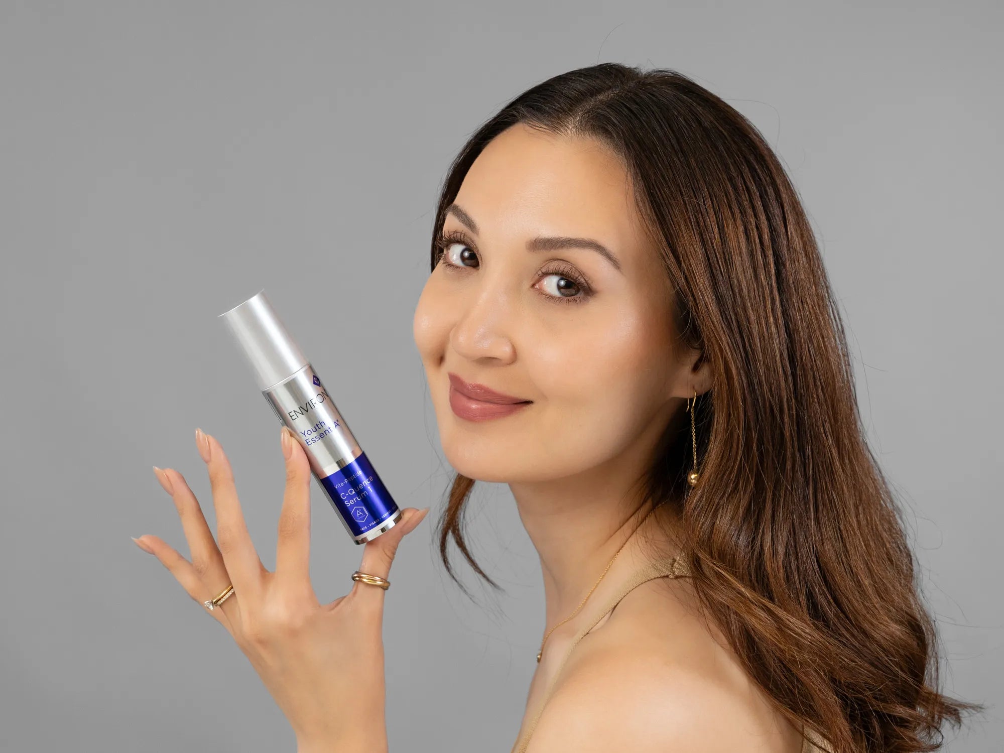 Laziza from LAZ Skincare holding a bottle of Environ C-Quence Serum up to her face