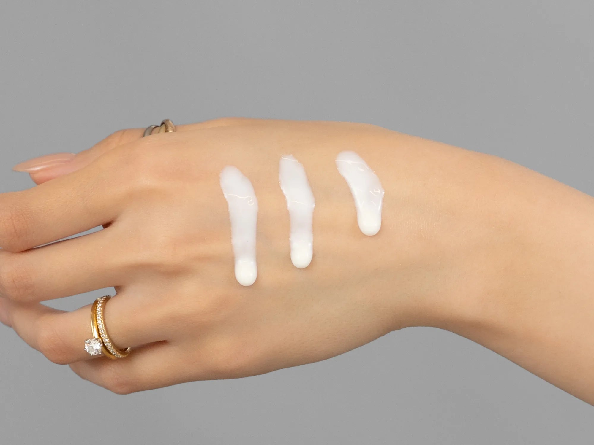 Laziza from LAZ Skincare demonstrating the texture and application of Environ C-Quence Serum on her hand