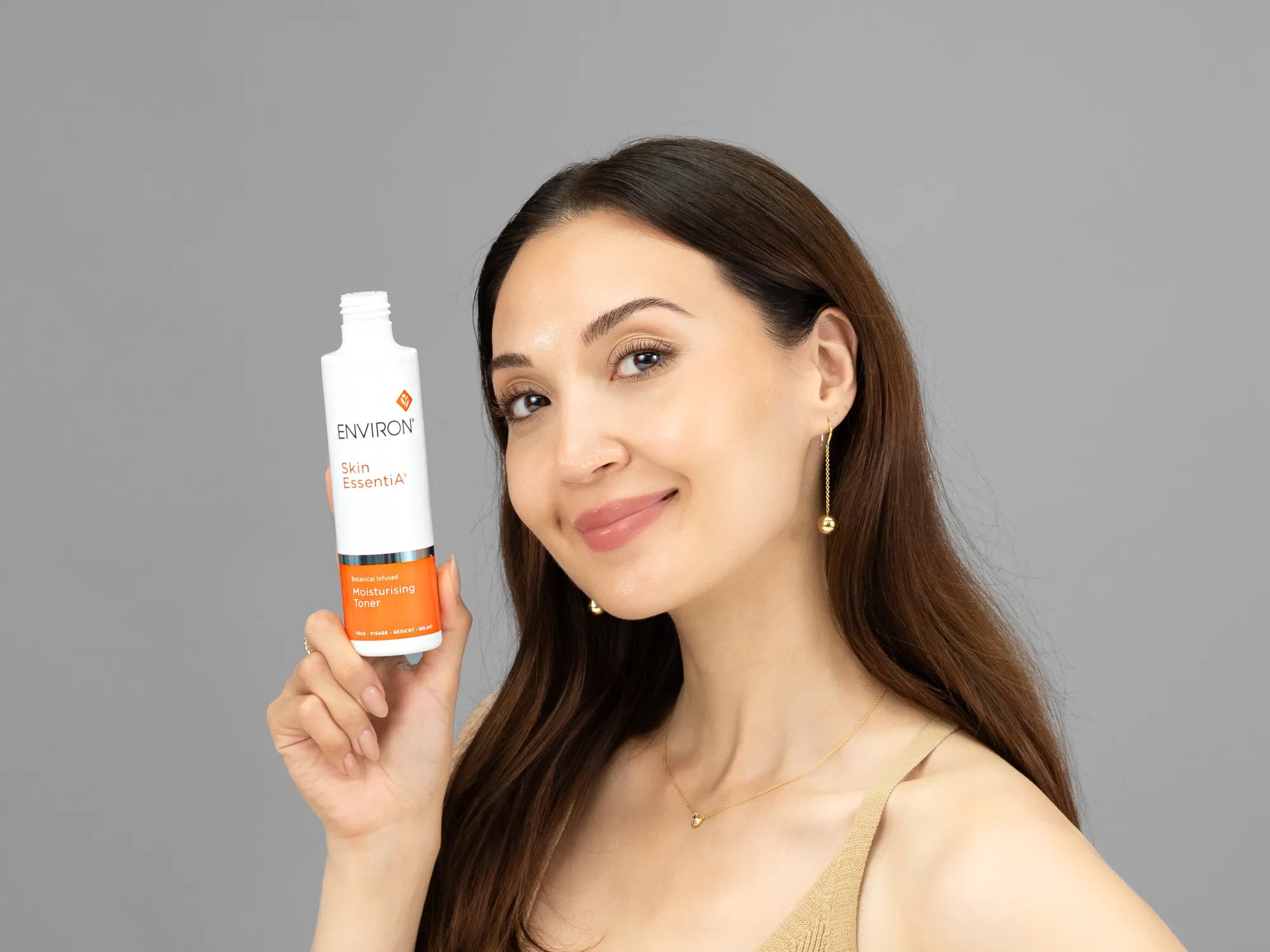 Laziza from LAZ Skincare holding a bottle of Environ Moisturising Toner up to her face