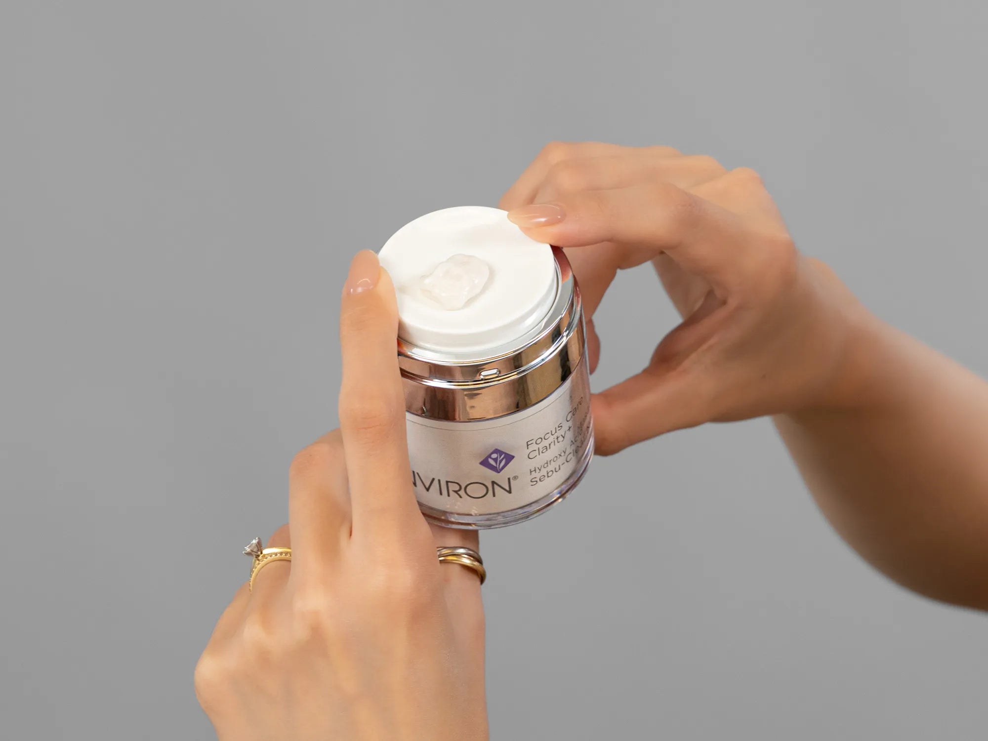 Closeup of Laziza from LAZ Skincare holding up a bottle of Environ Sebu-Clear Masque