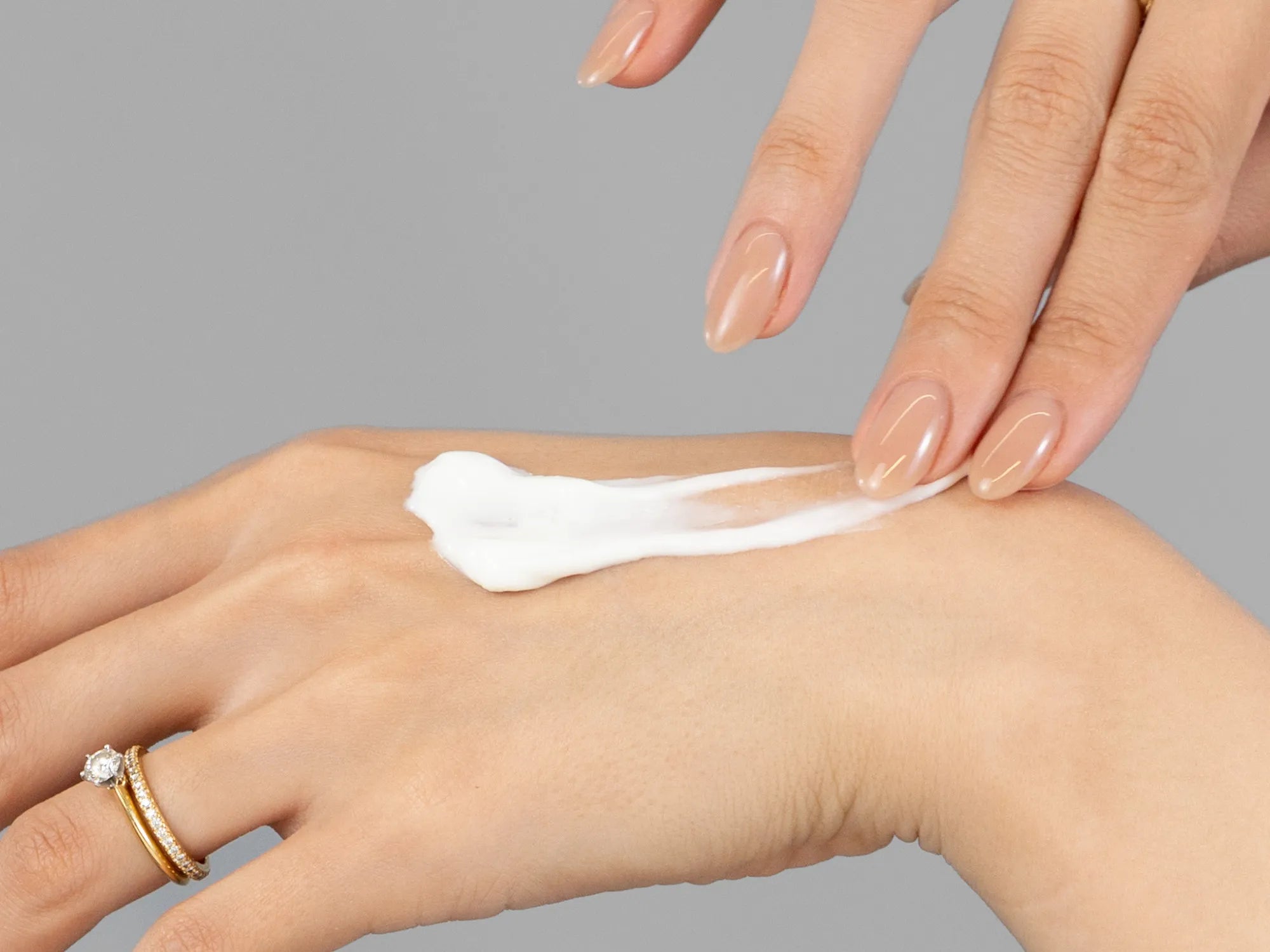 Laziza from LAZ Skincare demonstrating the texture and application of Epicuren After Bath Moisturizer on her hand