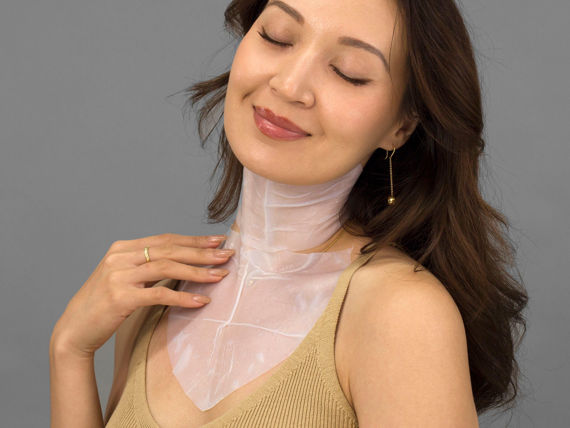 Laziza from LAZ Skincare demonstrating how to apply the Epicutis Lipid Recovery Mask to her neck and decollete