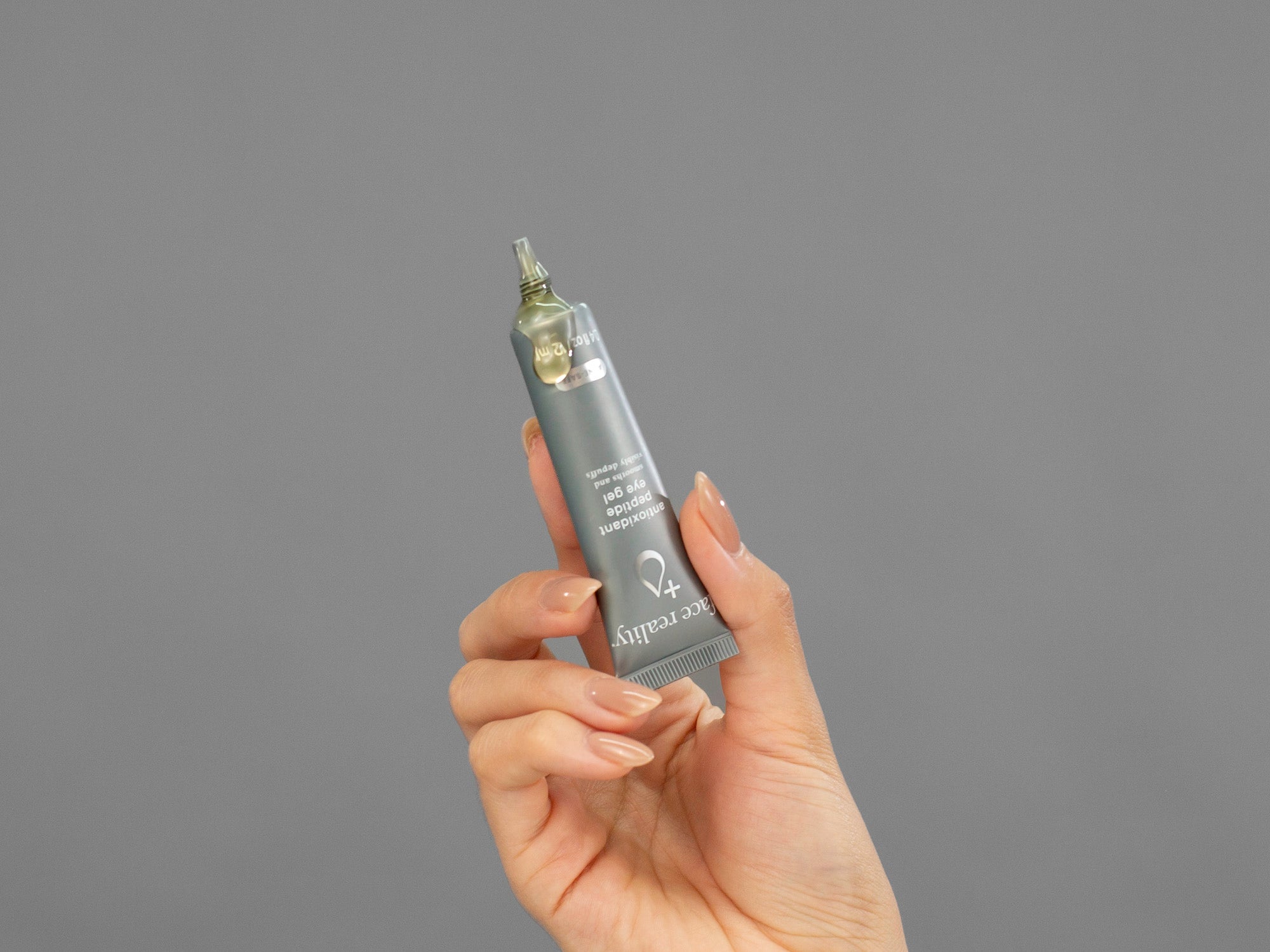 Closeup of Laziza from LAZ Skincare squeezing a tube of Face Reality Antioxidant Peptide Eye Gel