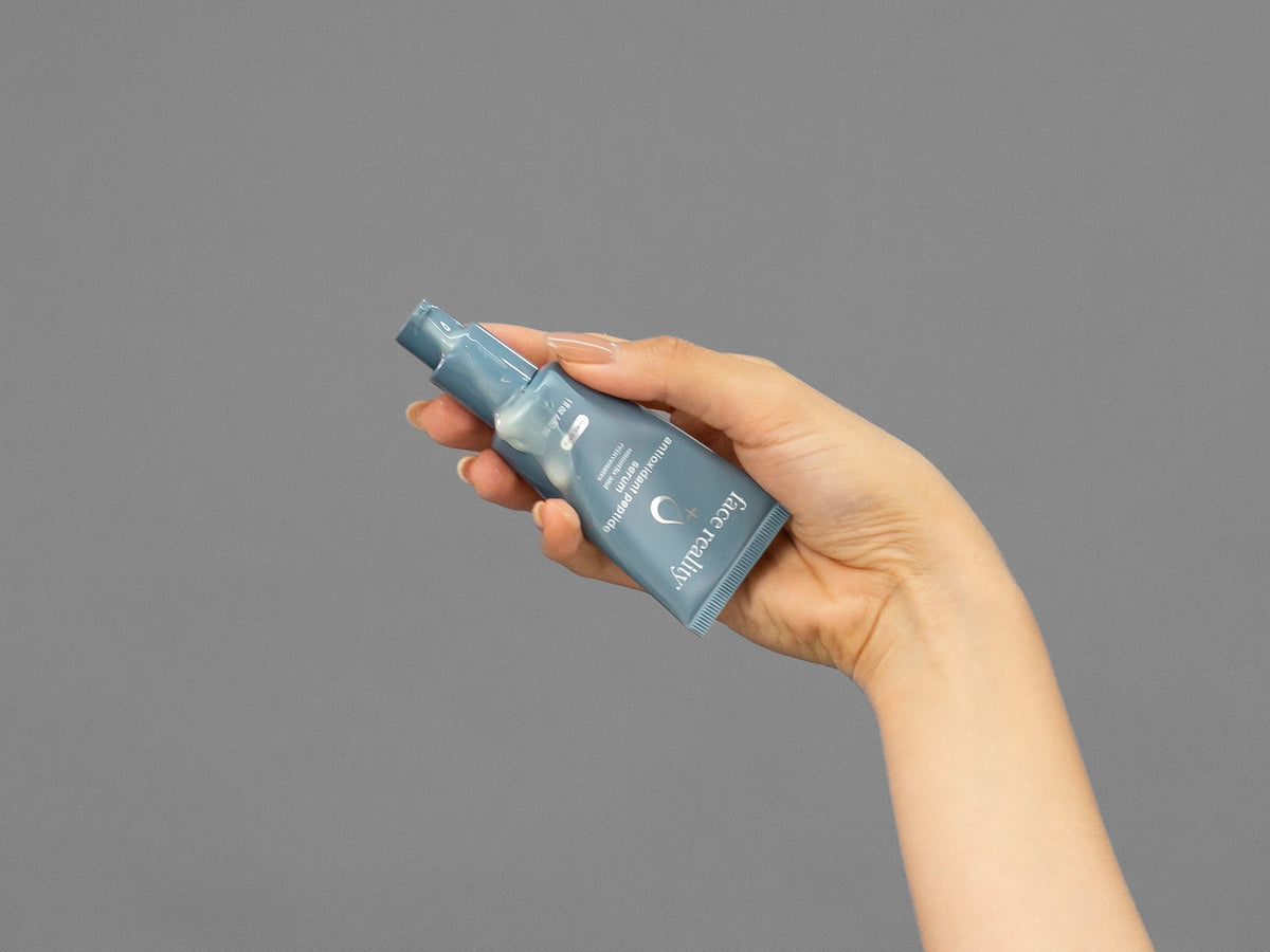 Closeup of Laziza from LAZ Skincare holding up a bottle of Face Reality Antioxidant Peptide Serum