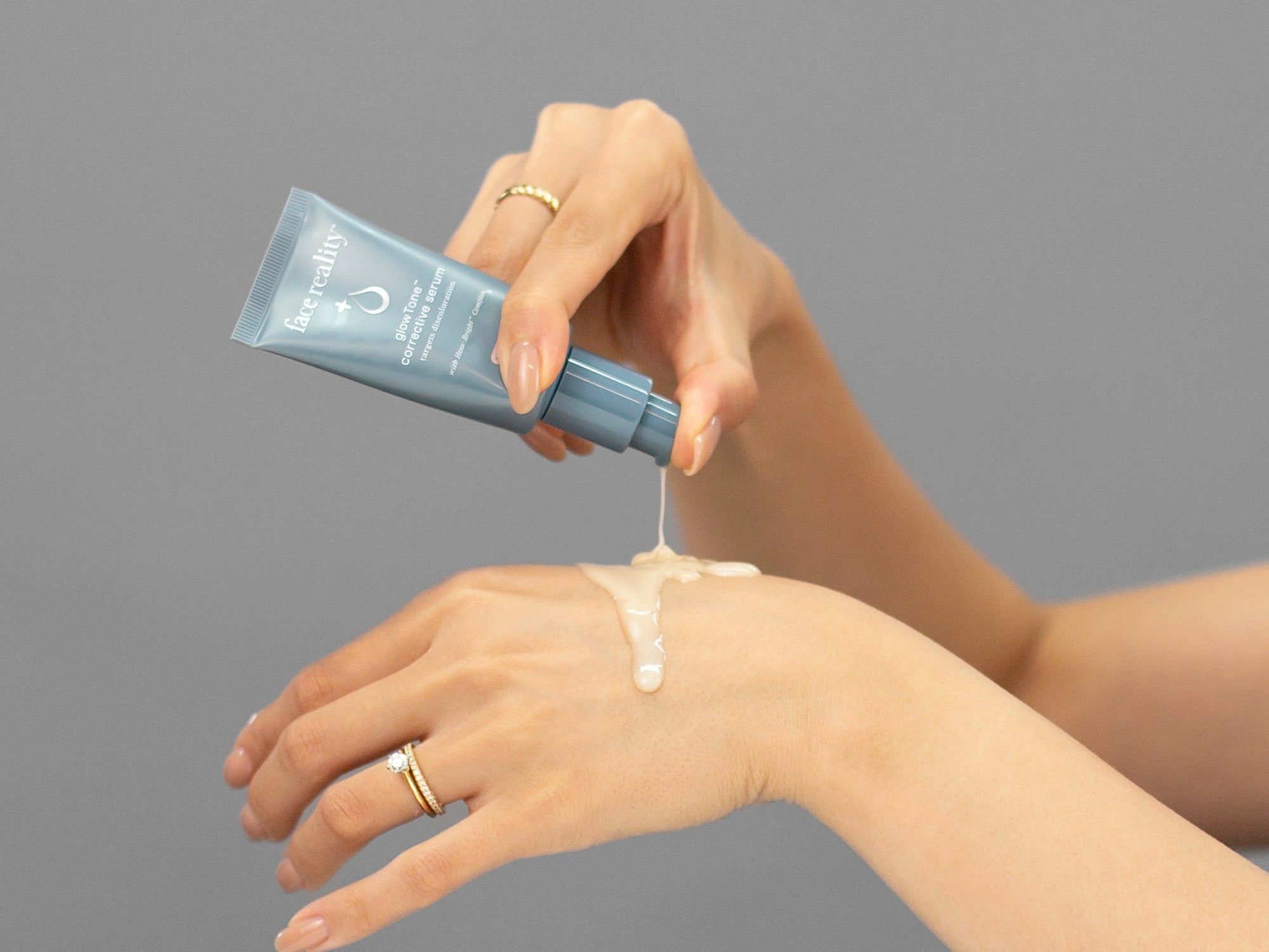 Closeup of Laziza from LAZ Skincare holding up a bottle of Face Reality GlowTone Corrective Serum