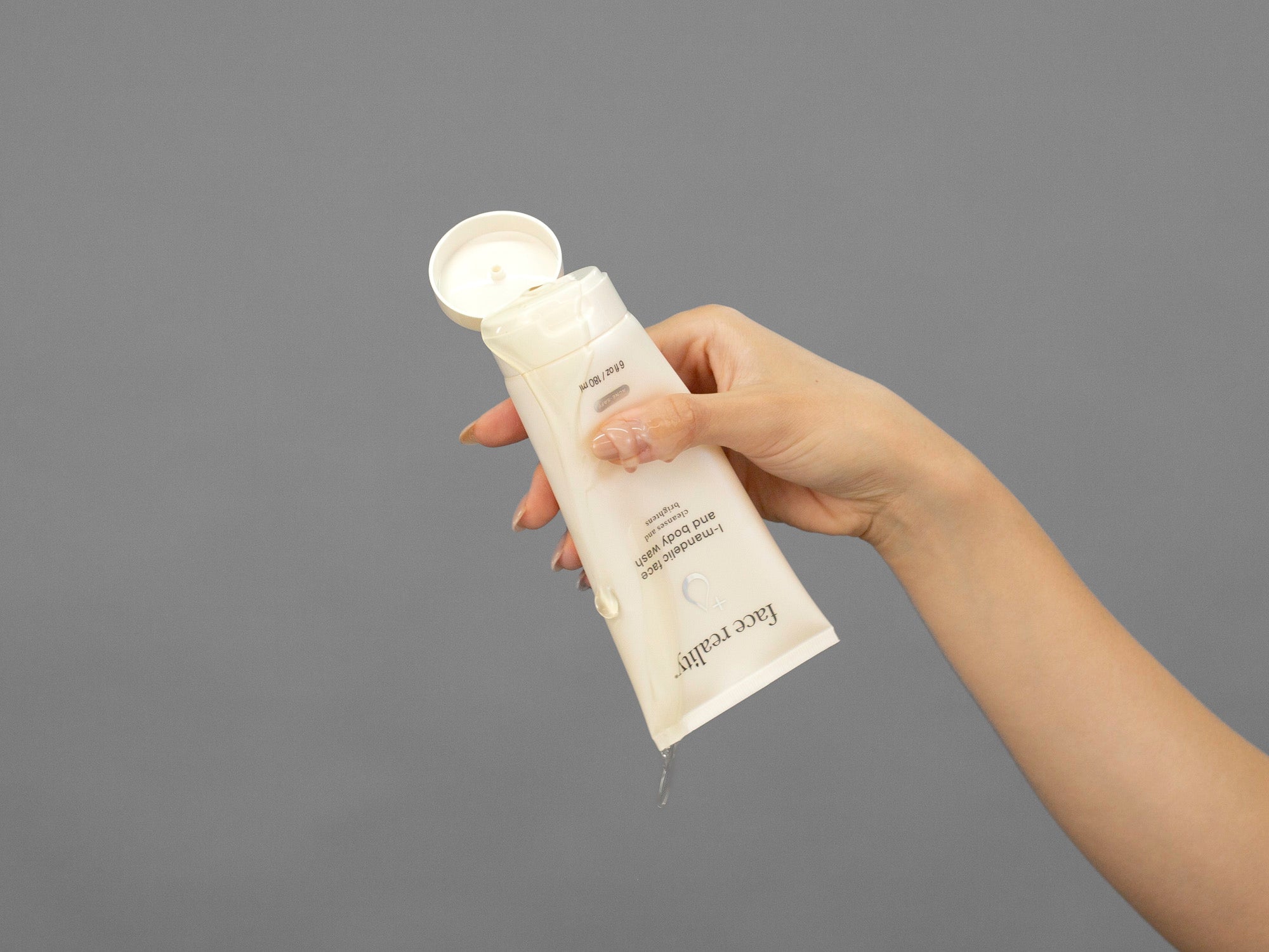 Closeup of Laziza from LAZ Skincare holding up a bottle of Face Reality Mandelic Face & Body Wash
