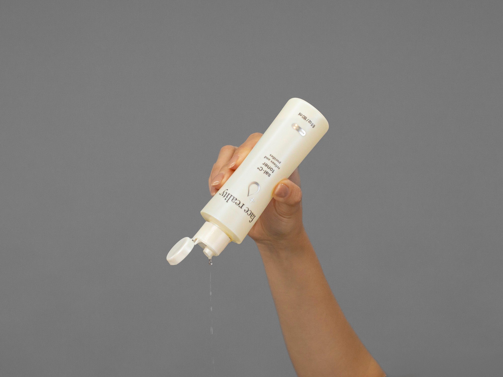 Closeup of Laziza from LAZ Skincare holding up a bottle of Face Reality Sal-C Toner