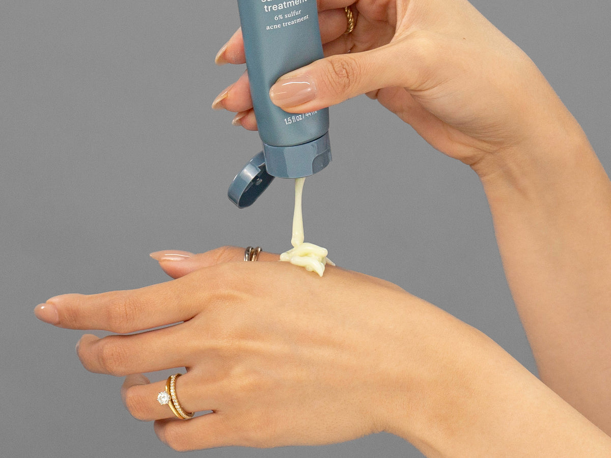 Laziza from LAZ Skincare demonstrating the texture and application of Face Reality Sulfur Spot Treatment on her hand
