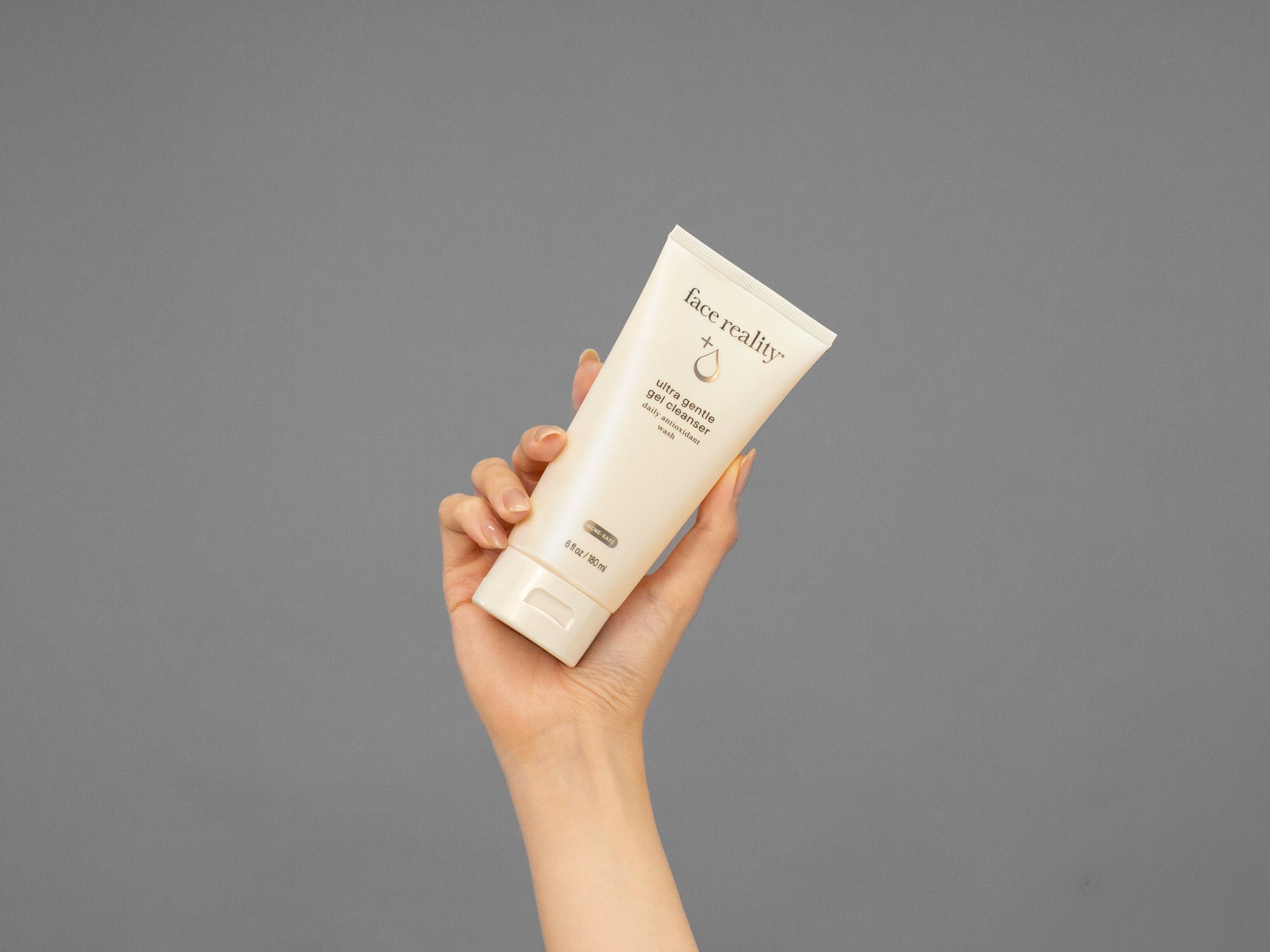 Closeup of Laziza from LAZ Skincare holding a tube of Face Reality Ultra Gentle Gel Cleanser in her hand