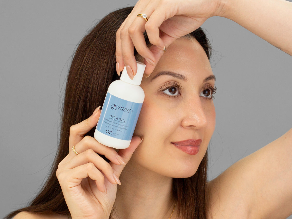 Laziza from LAZ Skincare holding a bottle of GlyMed Beta Gel up to her face