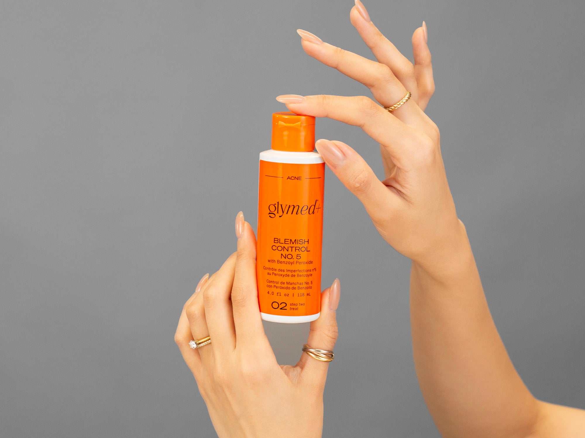 Closeup of Laziza from LAZ Skincare holding a bottle of GlyMed Blemish Control #5 in her hands