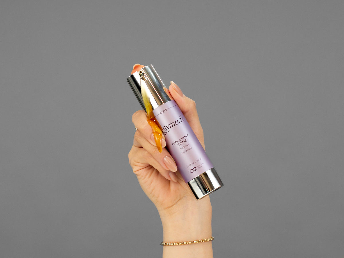 Closeup of Laziza from LAZ Skincare holding up a bottle of GlyMed Brilliant Tone