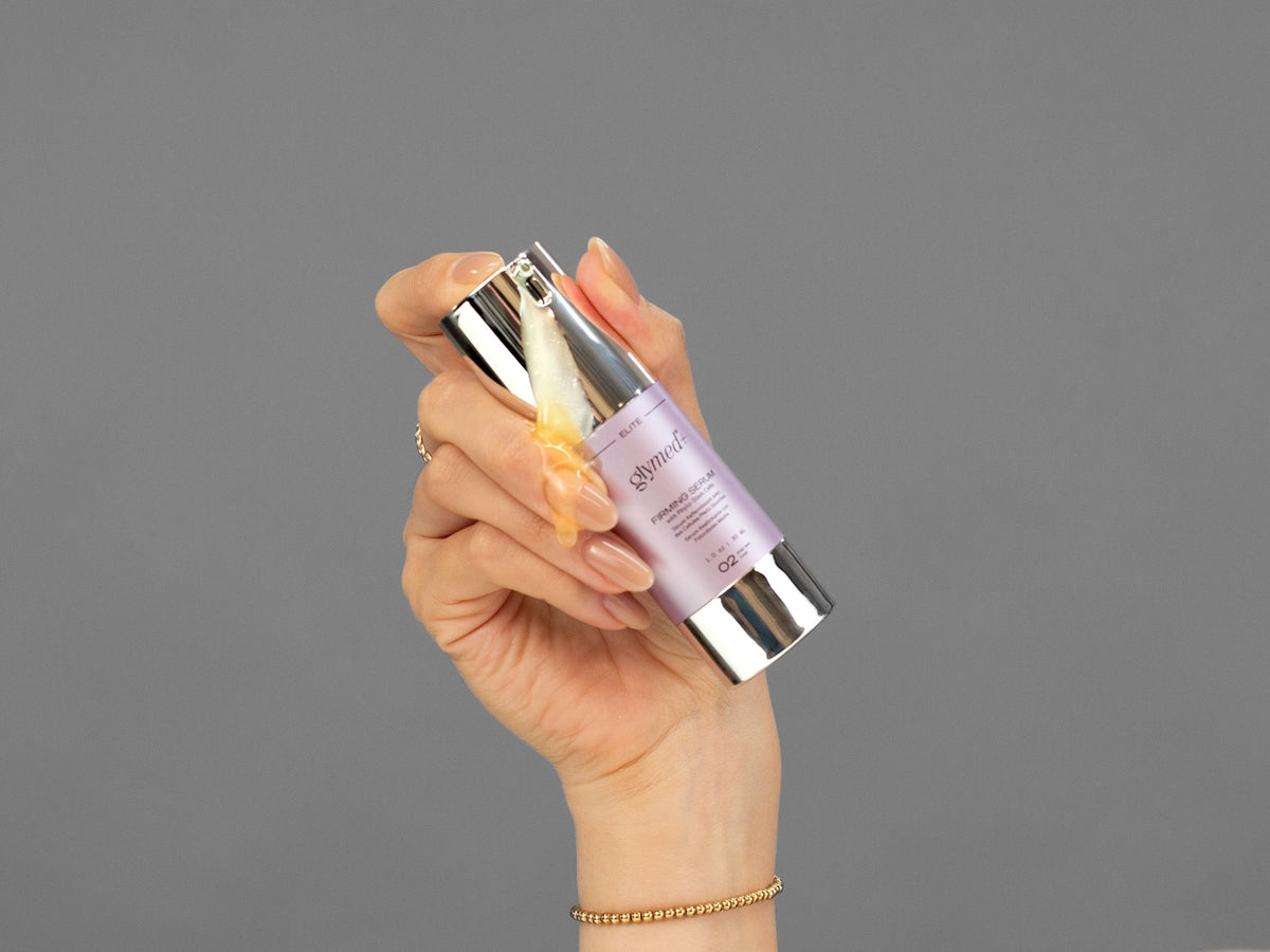 Closeup of Laziza from LAZ Skincare holding up a bottle of GlyMed Firming Serum