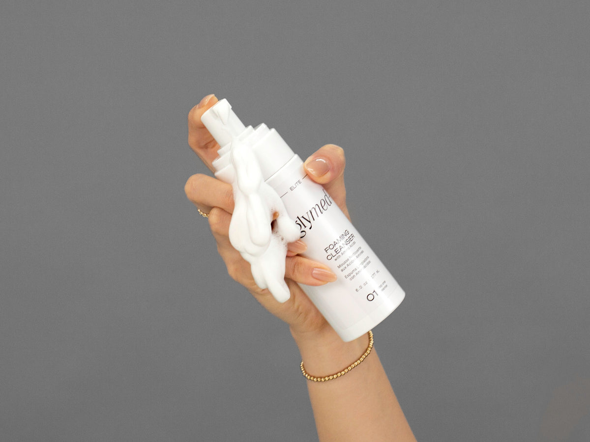 Closeup of Laziza from LAZ Skincare holding up a bottle of GlyMed Foaming Cleanser