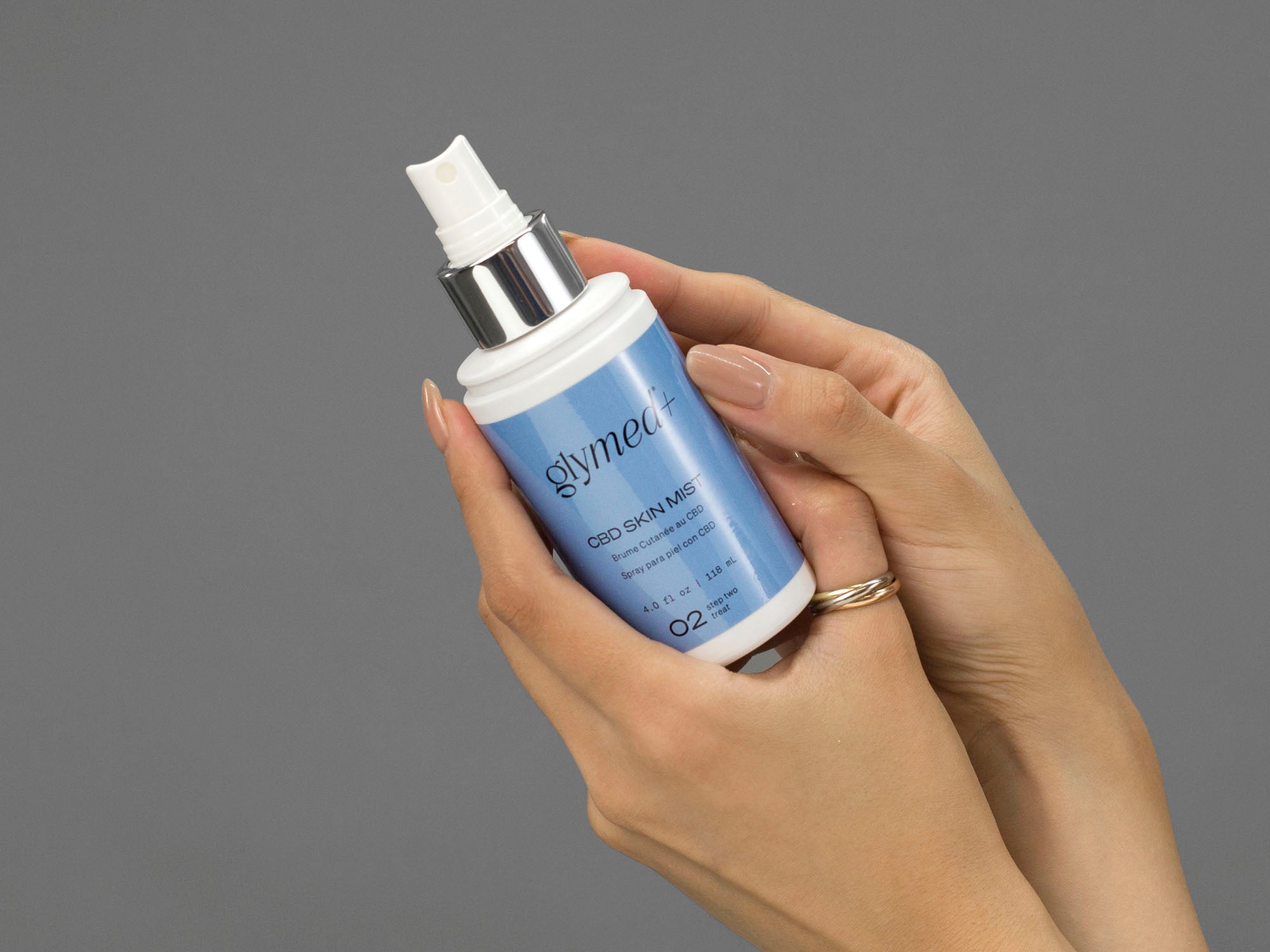 Closeup of Laziza from LAZ Skincare holding up a bottle of GlyMed Hemp Skin Mist