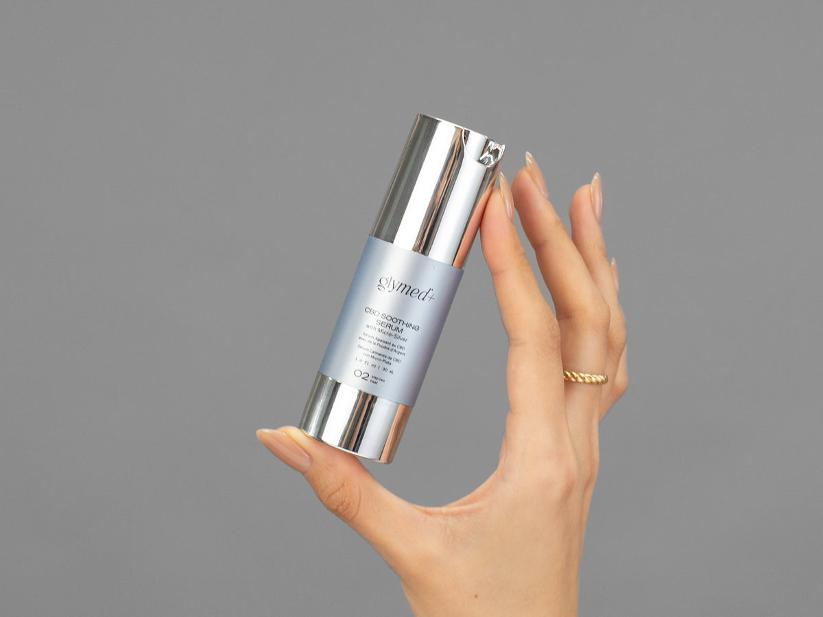 Closeup of Laziza from LAZ Skincare holding up a bottle of GlyMed Hemp Soothing Serum