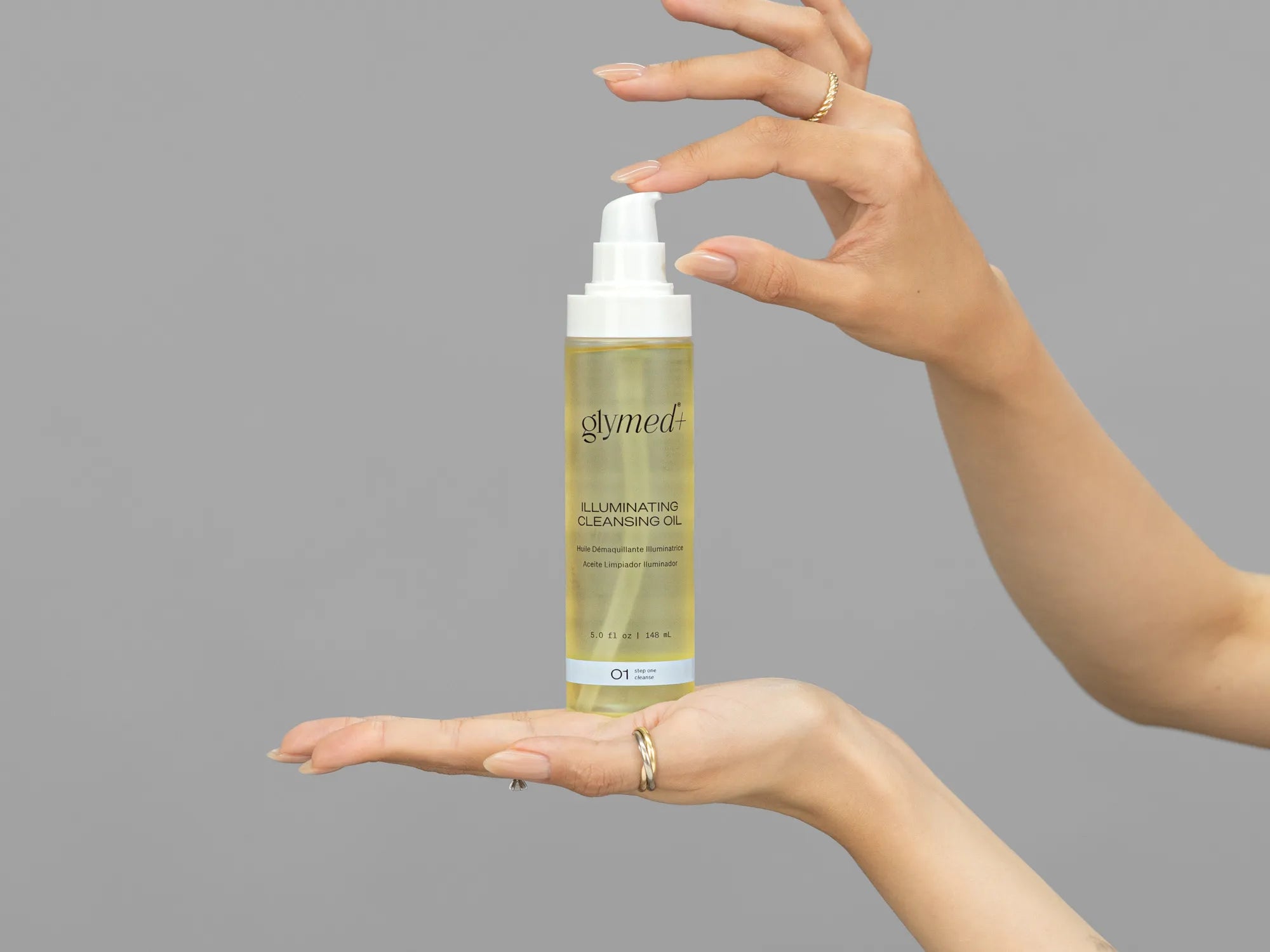 Closeup of Laziza from LAZ Skincare holding up a bottle of GlyMed Illuminating Cleansing Oil