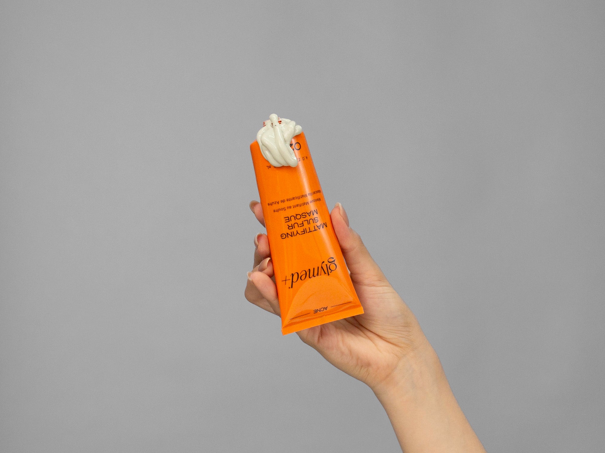 Closeup of Laziza from LAZ Skincare holding up a bottle of GlyMed Mattifying Sulfur Masque