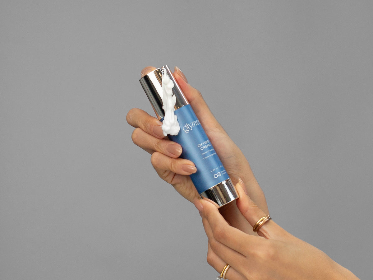 Closeup of Laziza from LAZ Skincare holding up a bottle of GlyMed Oxygen Cream