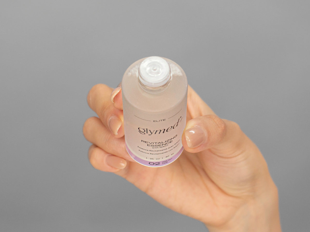 Closeup of Laziza from LAZ Skincare holding up a bottle of GlyMed Revitalizing Essence