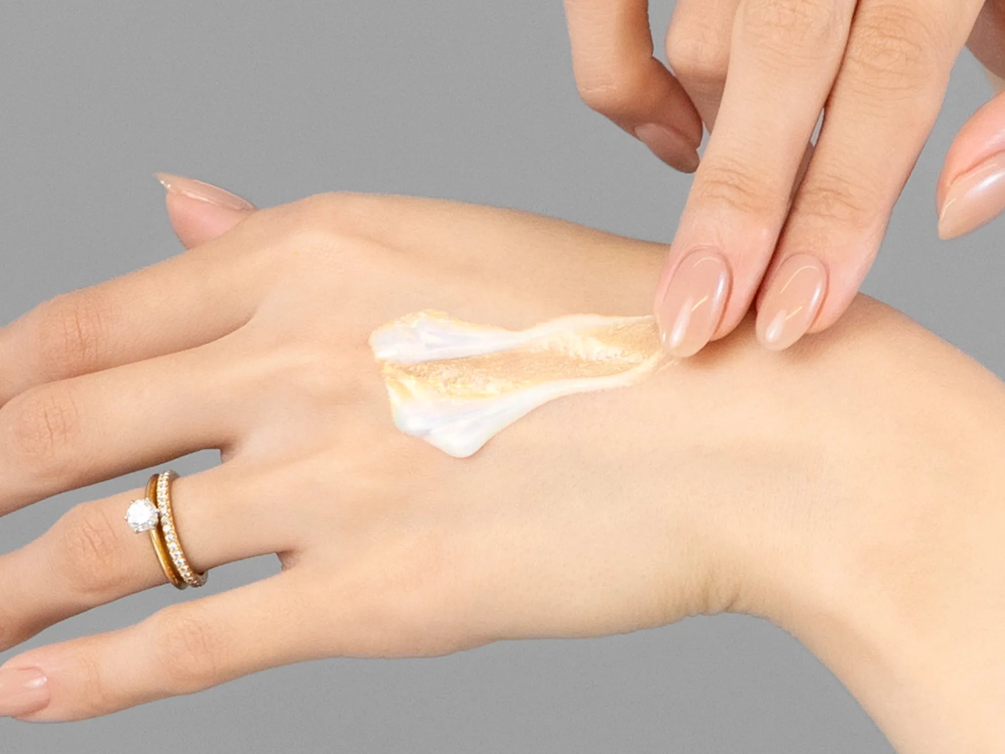 Laziza from LAZ Skincare demonstrating the texture and application of Hale & Hush Brilliant Eye & Lip Serum on her hand