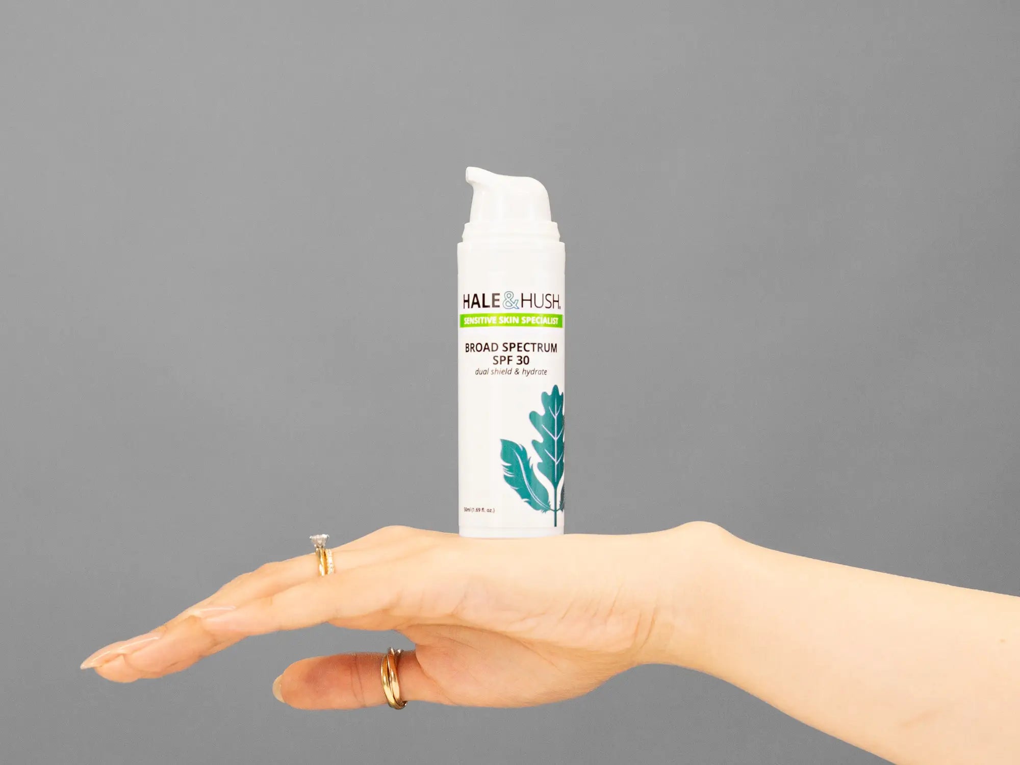 Closeup of Laziza from LAZ Skincare holding up a bottle of Hale & Hush Broad Spectrum Natural SPF30