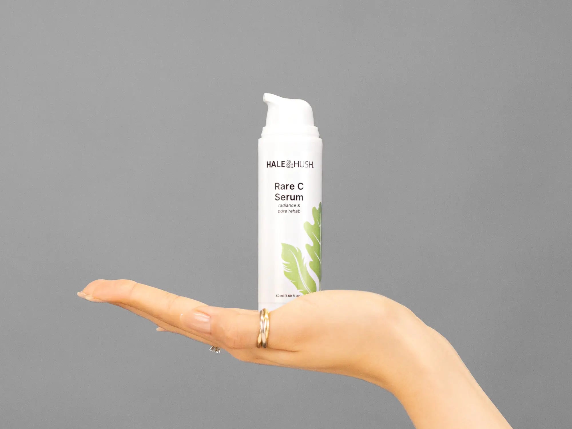 Closeup of Laziza from LAZ Skincare holding up a bottle of Hale & Hush Rare C Serum