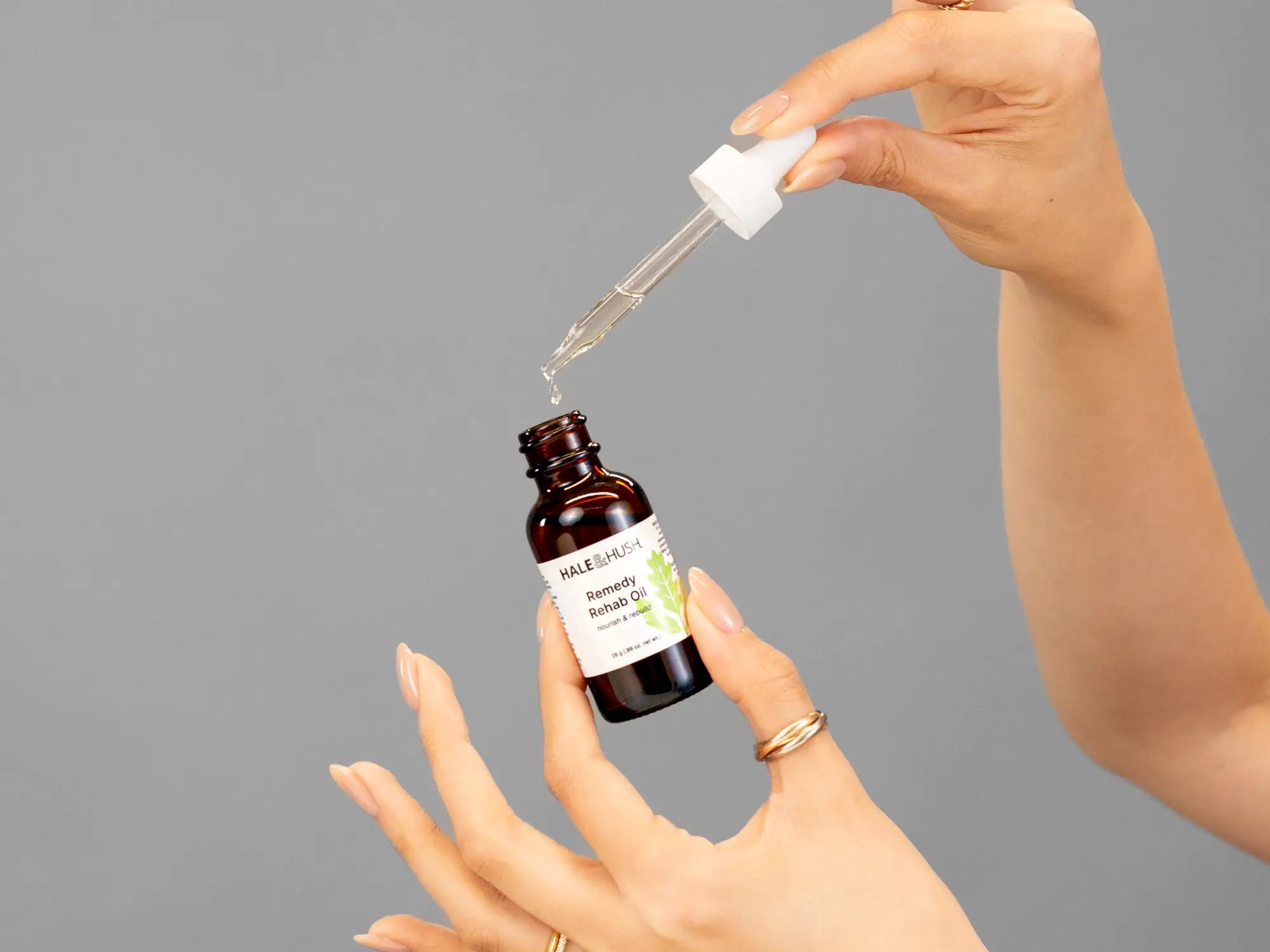 Closeup of Laziza from LAZ Skincare holding up a bottle of Hale & Hush Remedy Rehab Oil